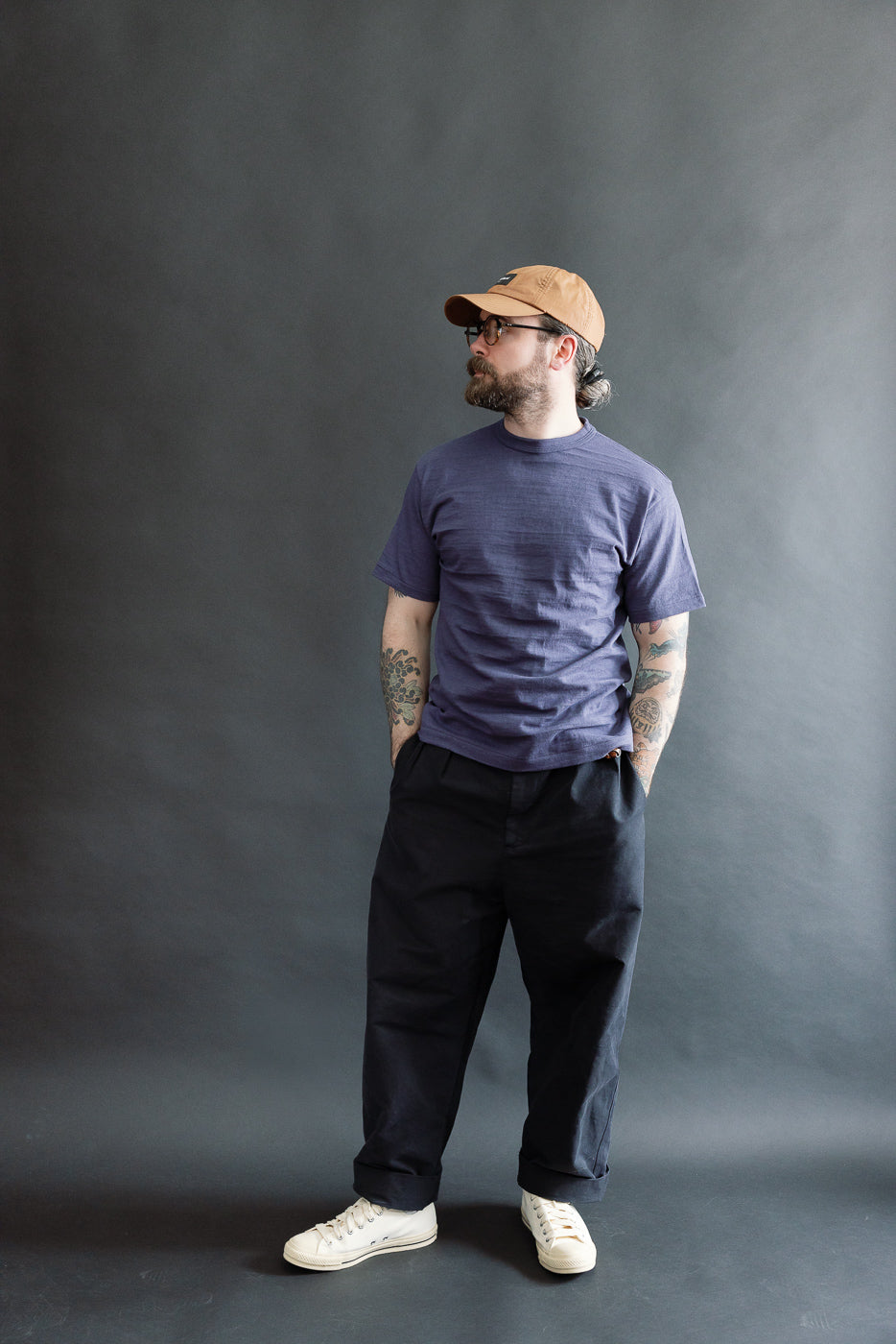 Full body front view of male model, 5'9, 165lbs, athletic build, wearing slubby heather eggplant cotton t-shirt and dark pants.