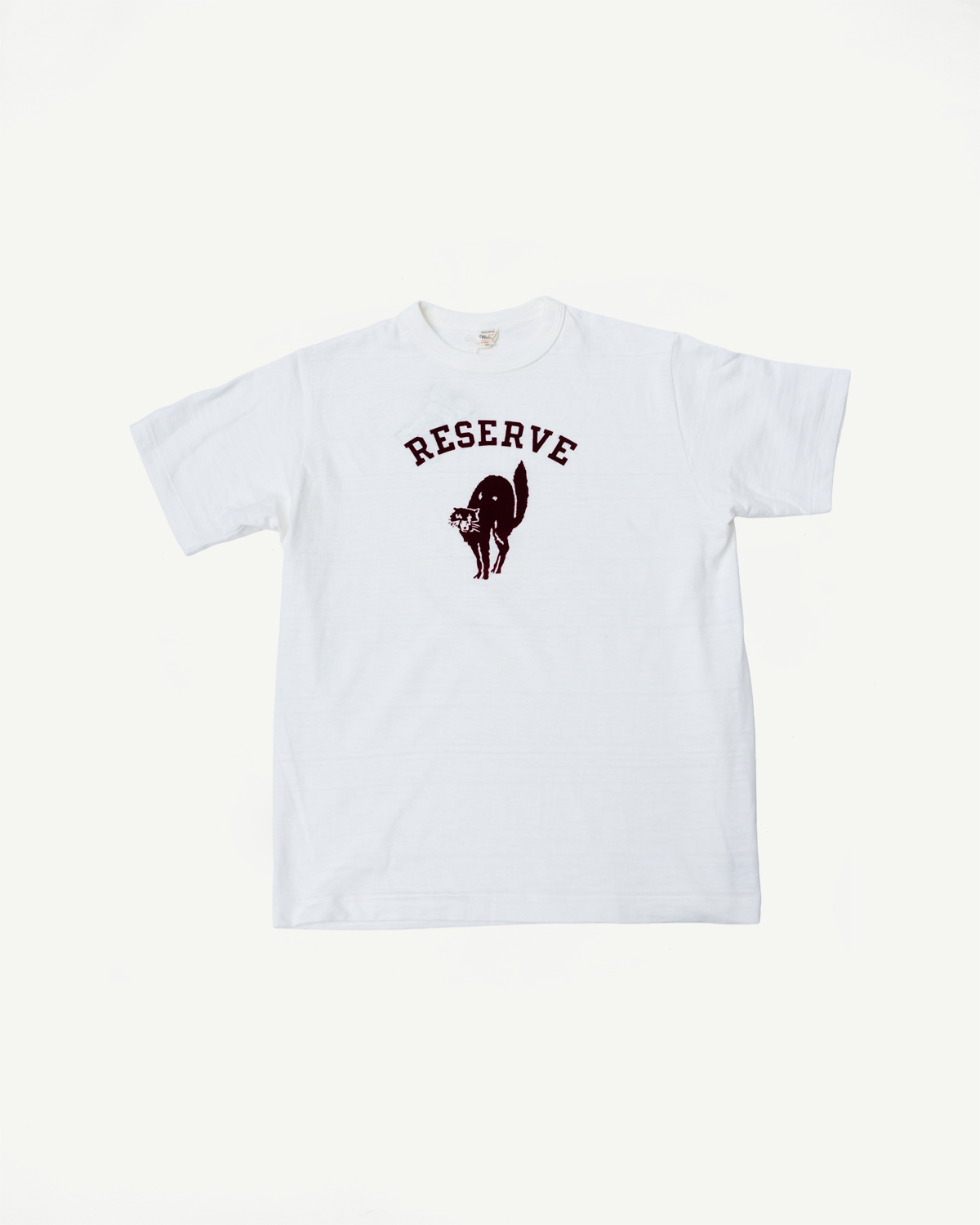 Front flat lay of Warehouse & Co Lot 4601 slubby cotton T-shirt in off-white with RESERVE graphic and black cat detail, short sleeves, standard crewneck, Dant contemporary casual apparel.