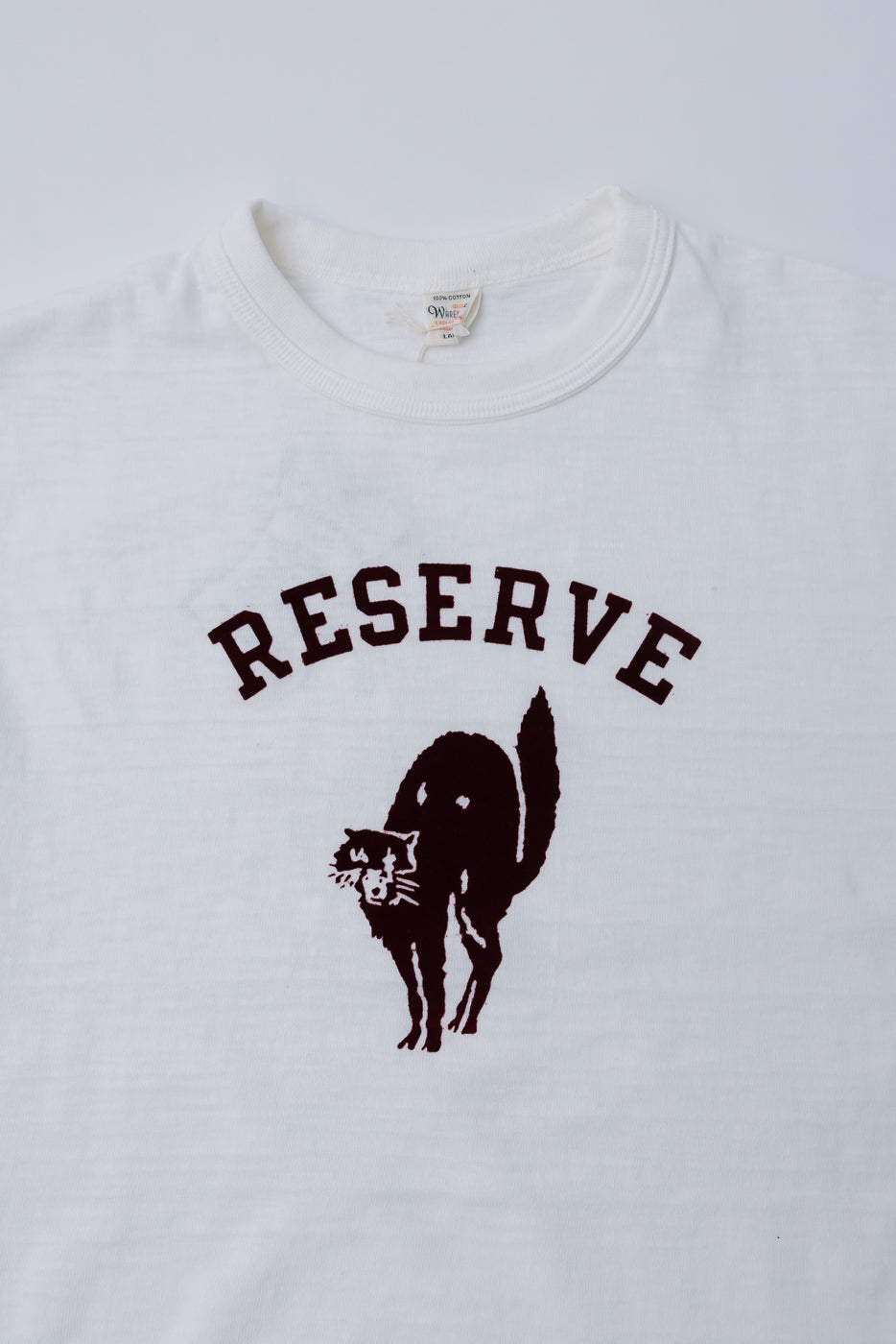 Close-up front of Warehouse & Co. slubby cotton off-white t-shirt with RESERVE cat graphic