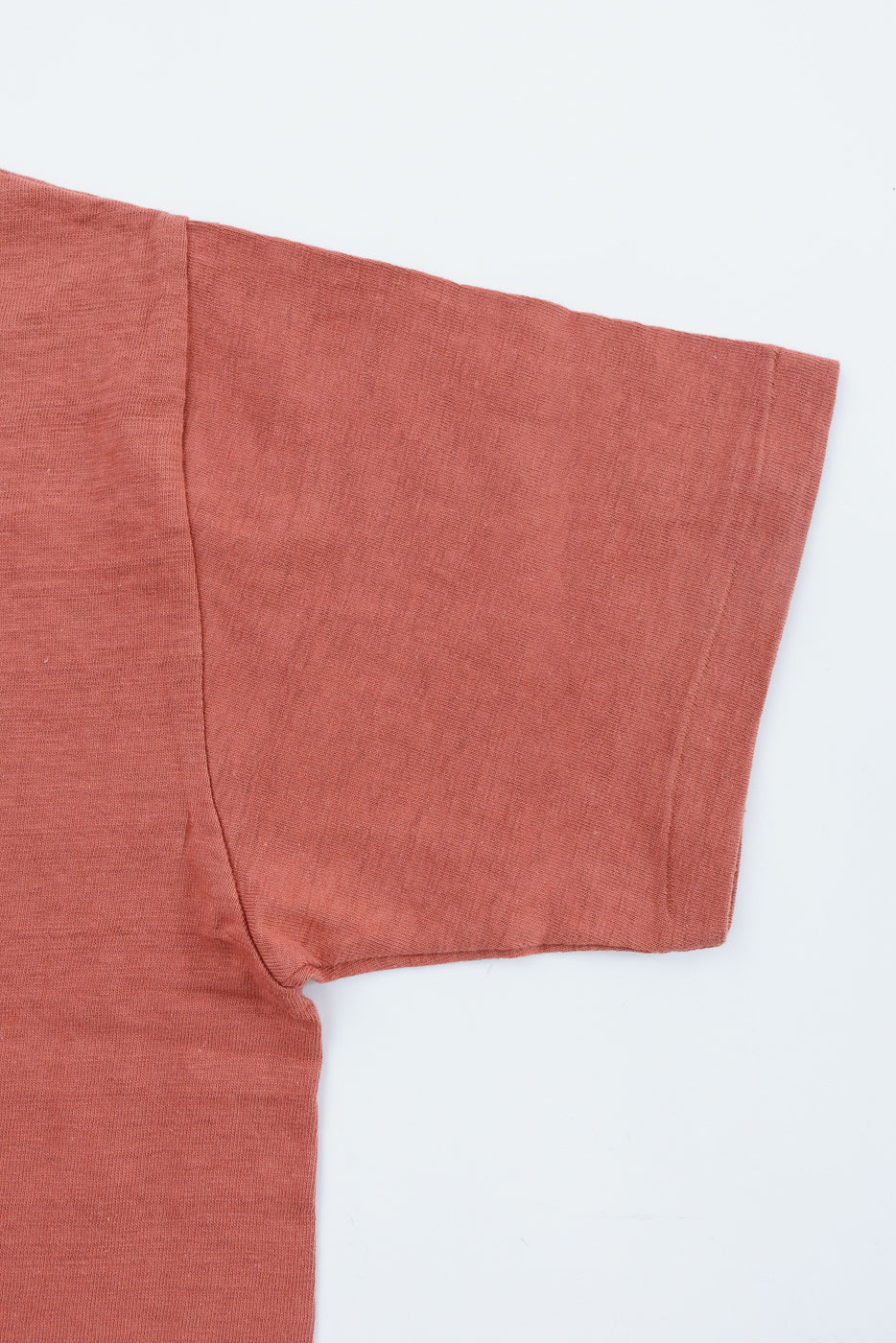 Lot 4601 - Slubby Cotton T-Shirt - Salmon, showcasing its textured short sleeve and upper side panel, highlighting the unique horizontal shadow effect knit from vintage 1960s machines, against a white background.