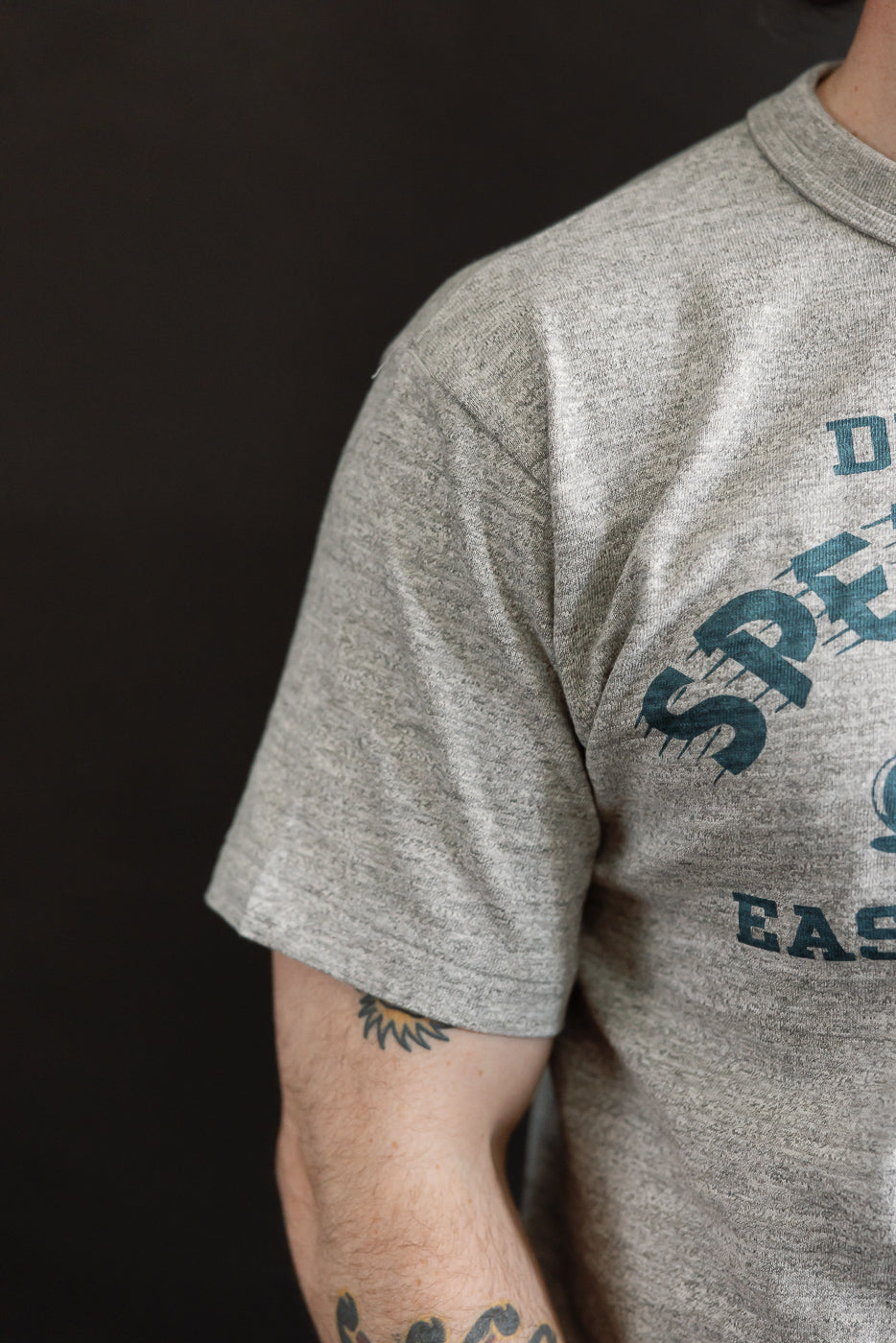 Close-up of front left chest and sleeve on Warehouse & Co. Lot 4601 heather slubby cotton t-shirt, worn by male model 5'9