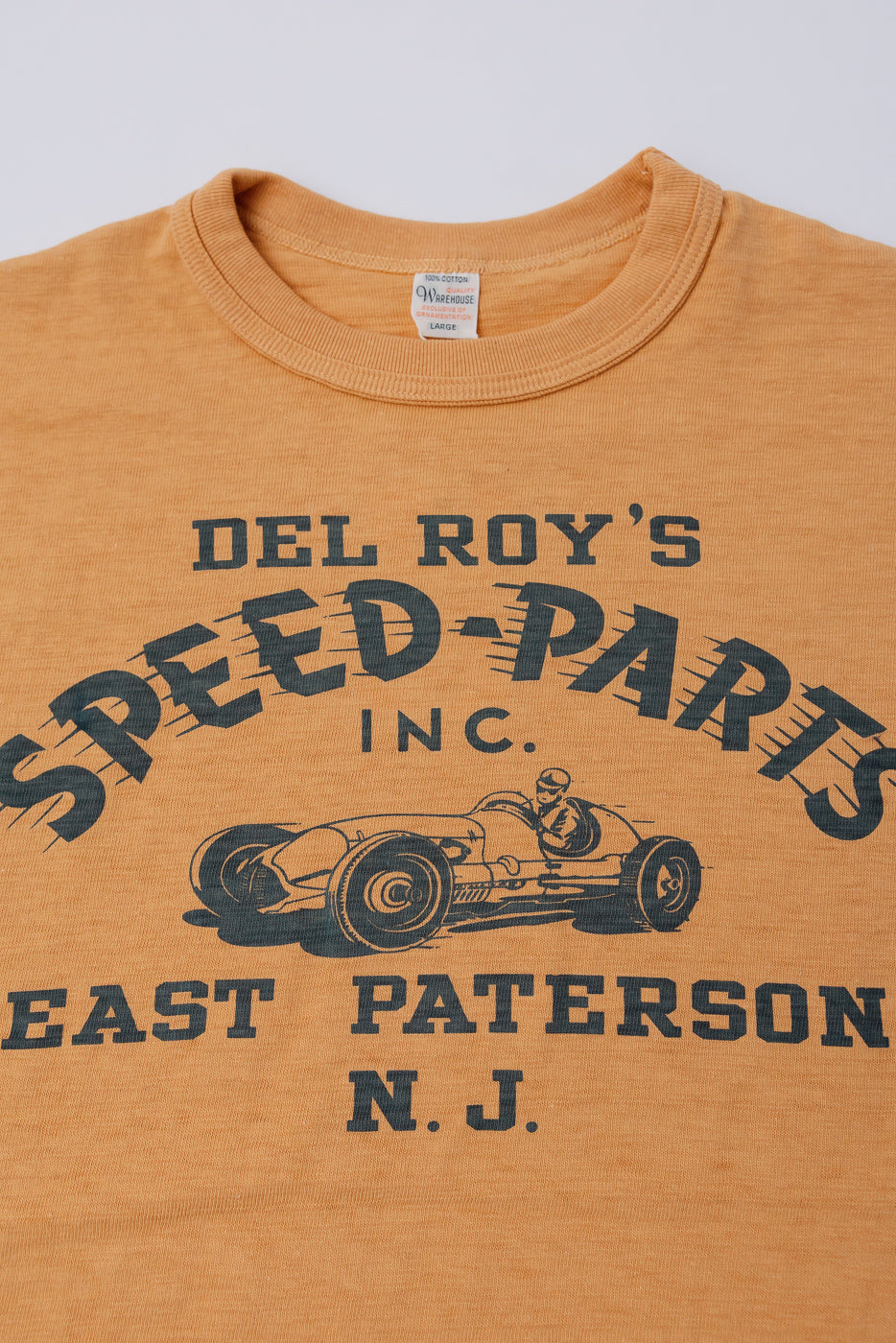 Close-up front of Warehouse & Co orange slubby cotton T-shirt, crewneck, chest graphic print, Dant