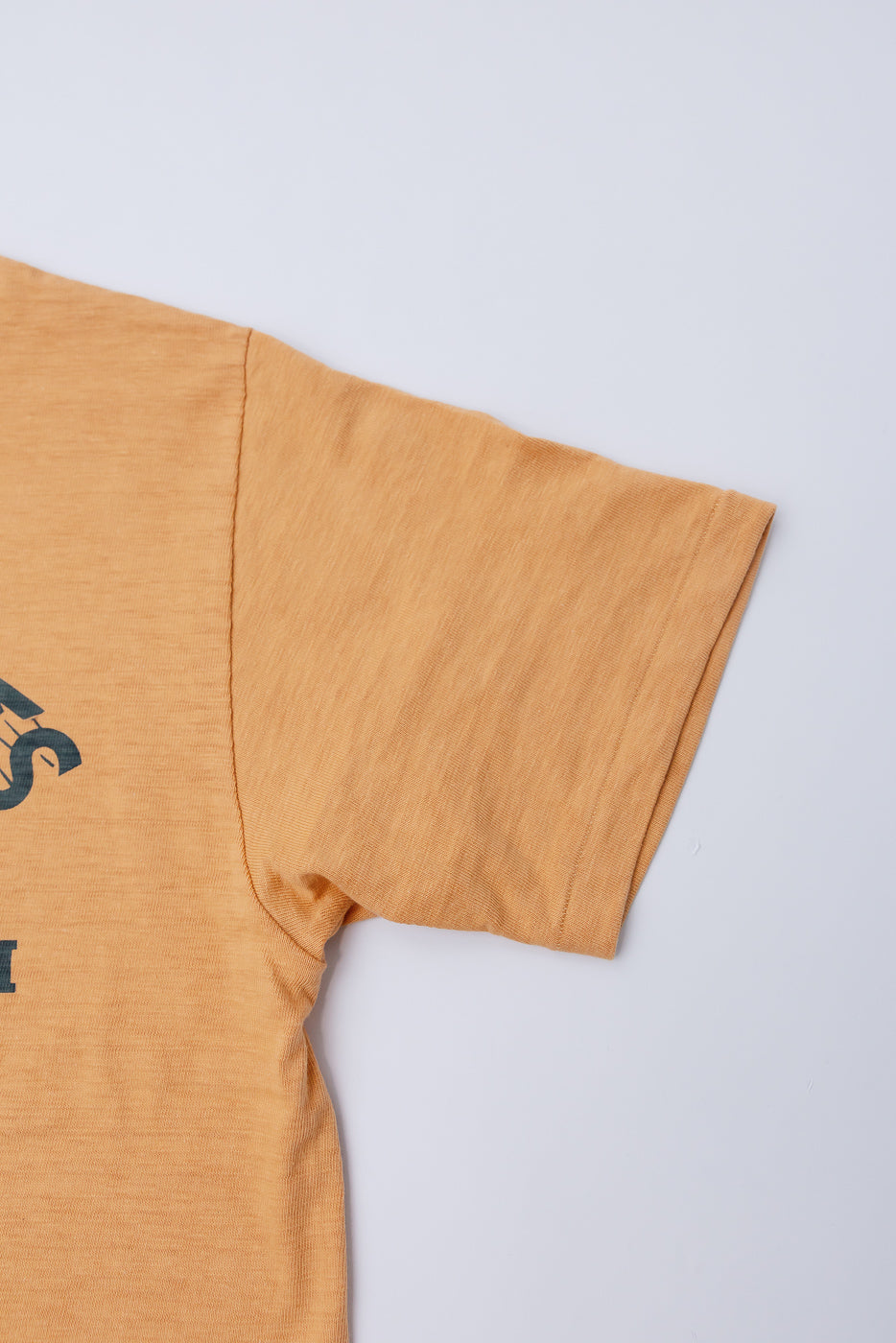 Close-up of left sleeve, front side, Warehouse & Co. slubby cotton orange t-shirt, fabric detail