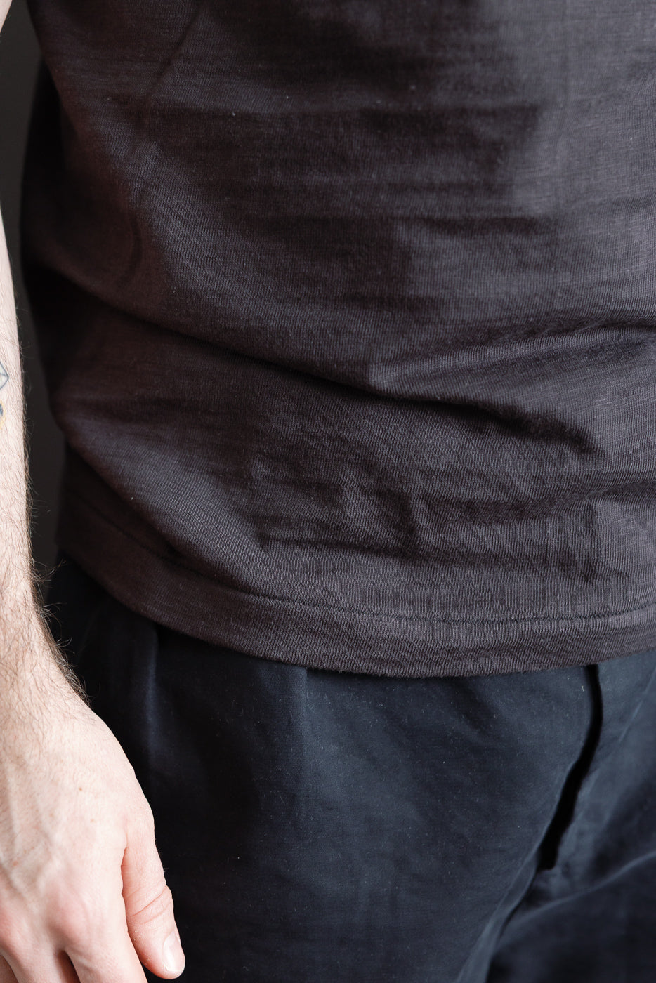 Close-up of slubby cotton black t-shirt hem, male model 5'9