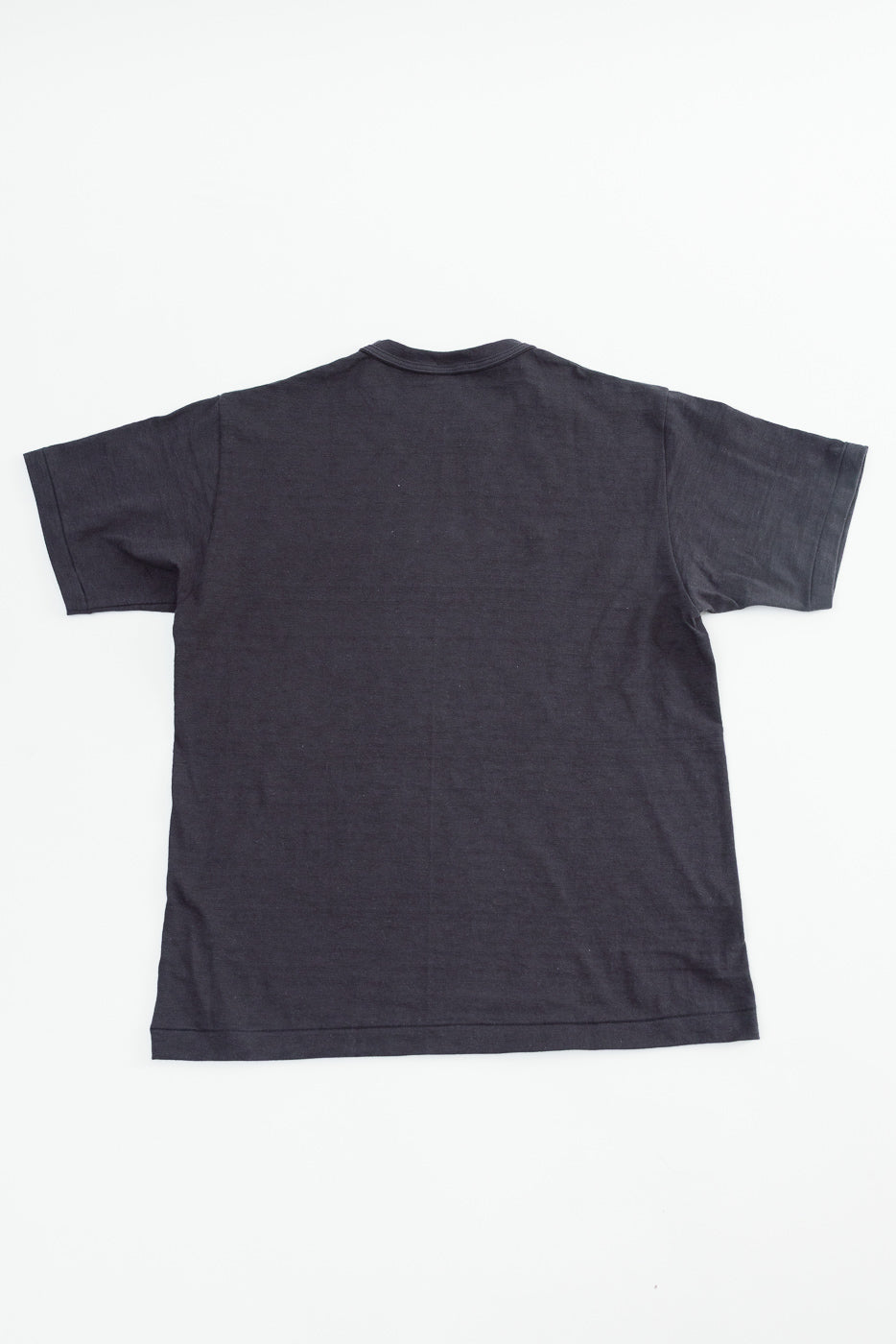 Flat lay of black slubby cotton t-shirt, back view, short sleeve, straight hem, no tags visible