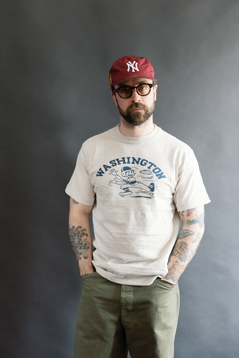 Front view full-body image of male model 5'9 165lbs athletic build in Warehouse & Co. Lot 4601 slubby oatmeal cotton T-shirt with 'Washington' graphic, casual fit, for Dant contemporary casual apparel.