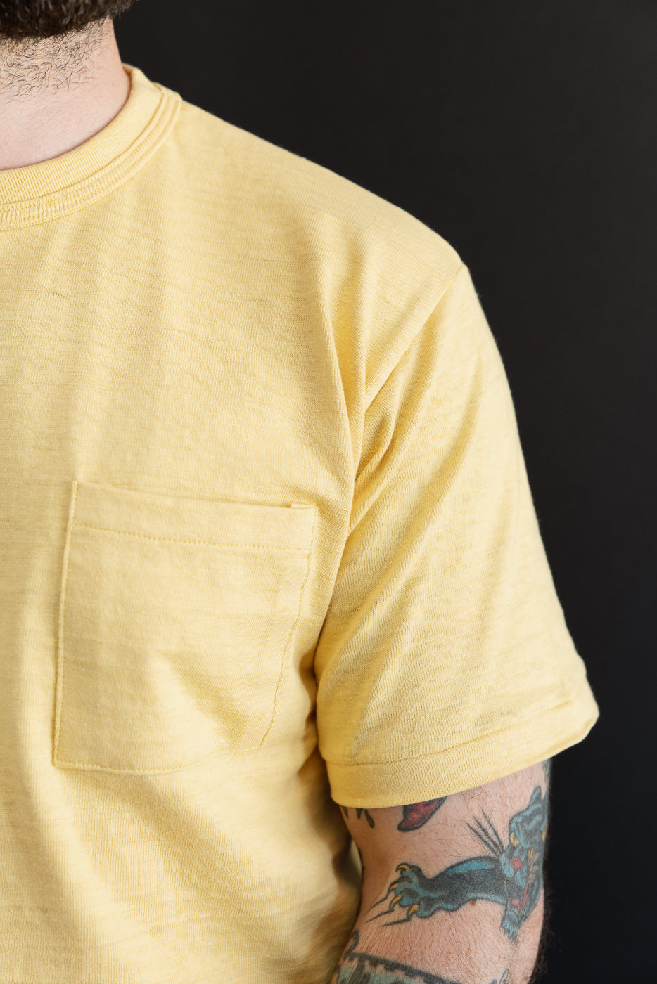 Close-up of front left side of yellow t-shirt on 5'9
