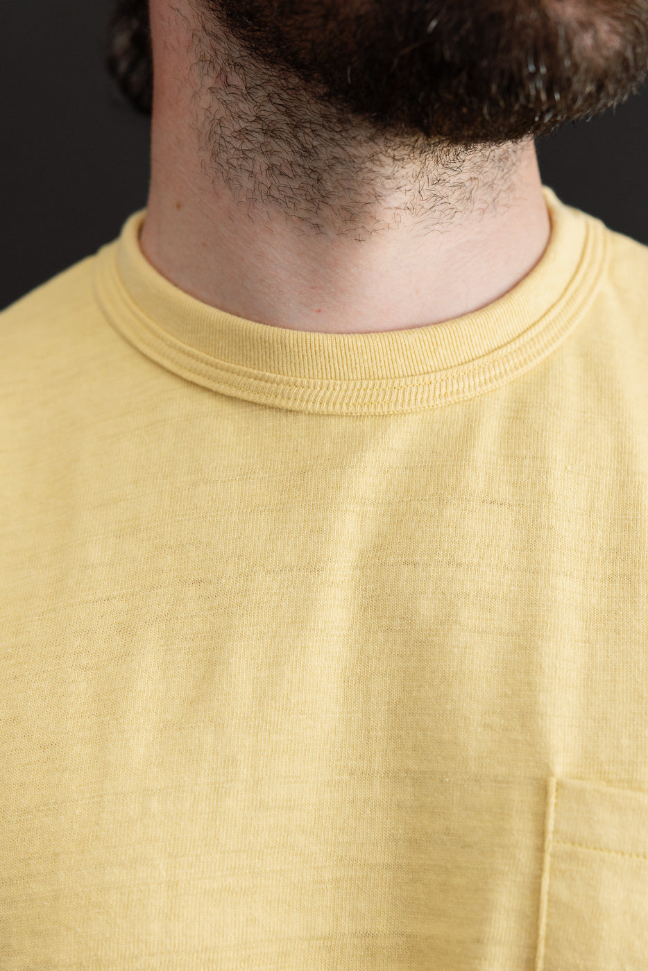 Close-up front view of a yellow t-shirt collar on a 5'9