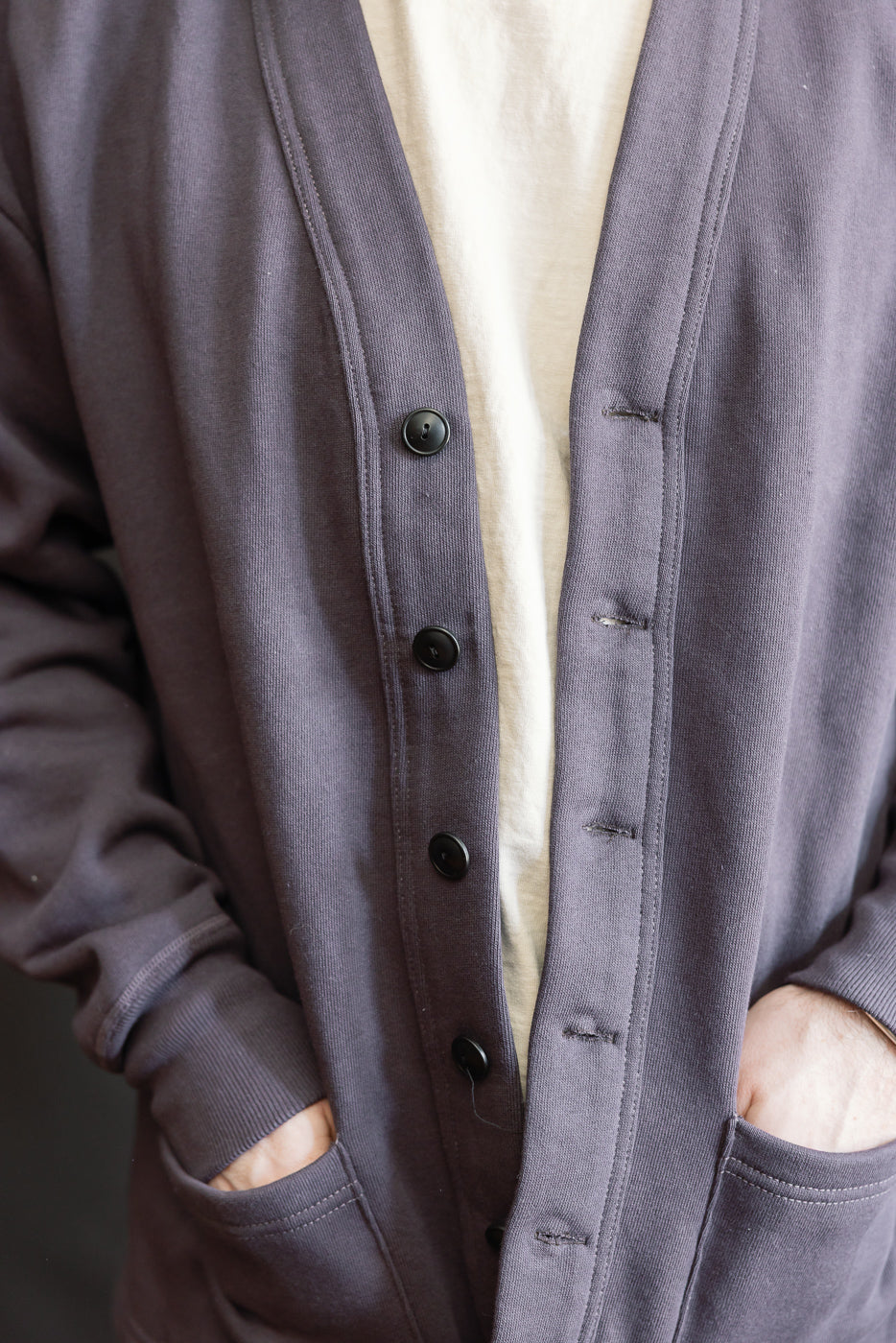 Close-up front view of dark navy sweat cardigan, button details, male model 5'9
