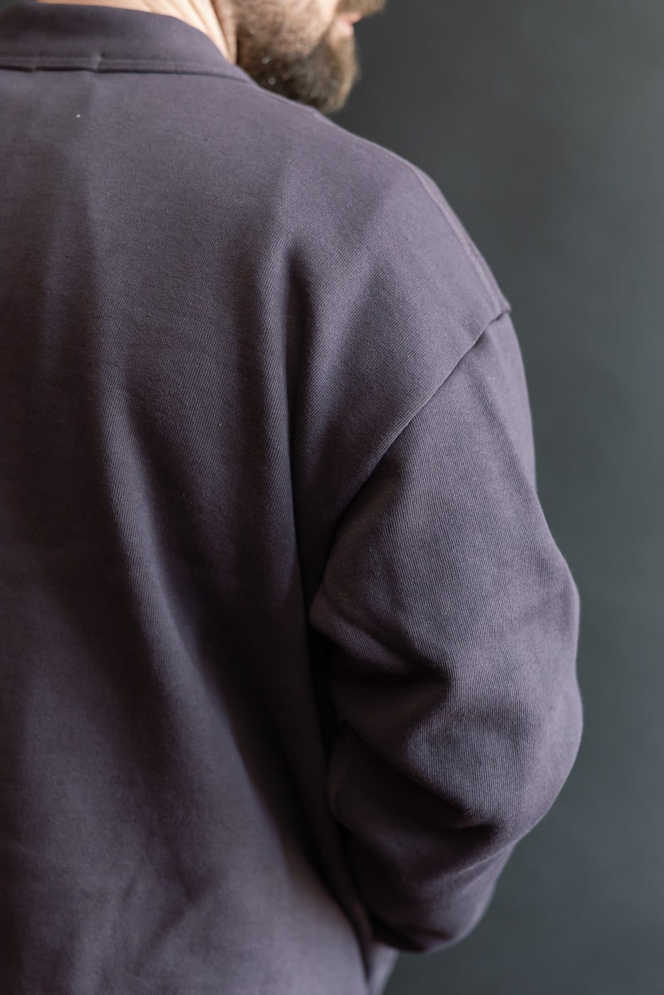 Close-up of men's dark navy sweatshirt cardigan, back right shoulder, on 5'9