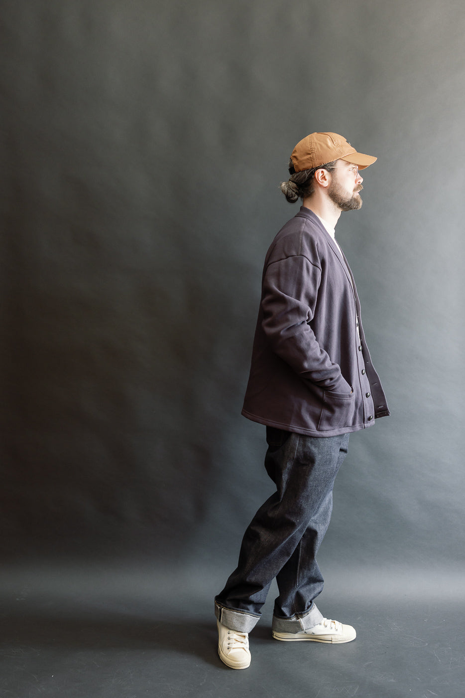 Male model 5'9, 165lbs athletic build, in side view, wearing dark navy cardigan, full body