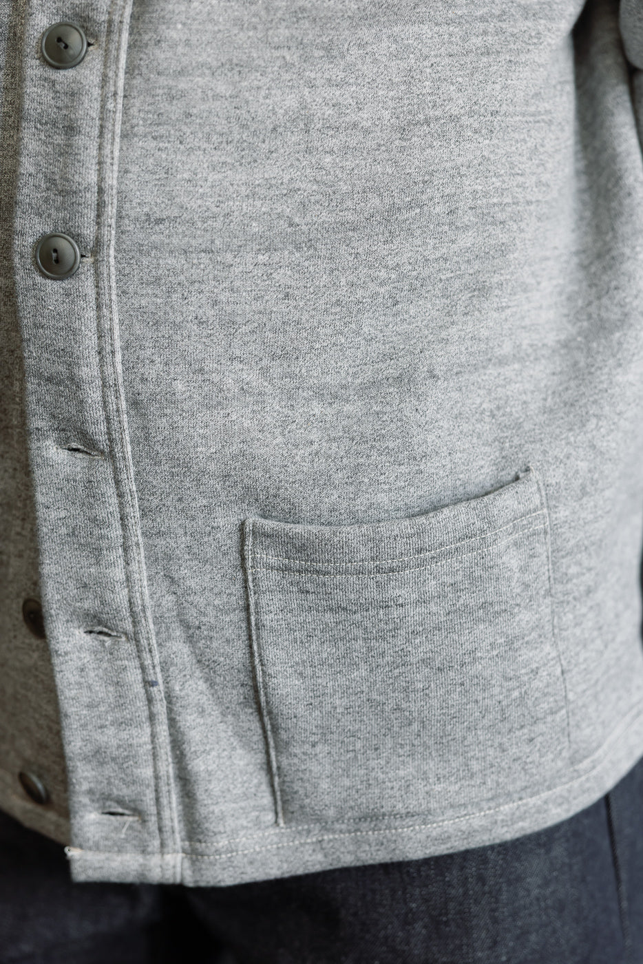 Close-up of front left pocket and buttons on heather grey sweat cardigan