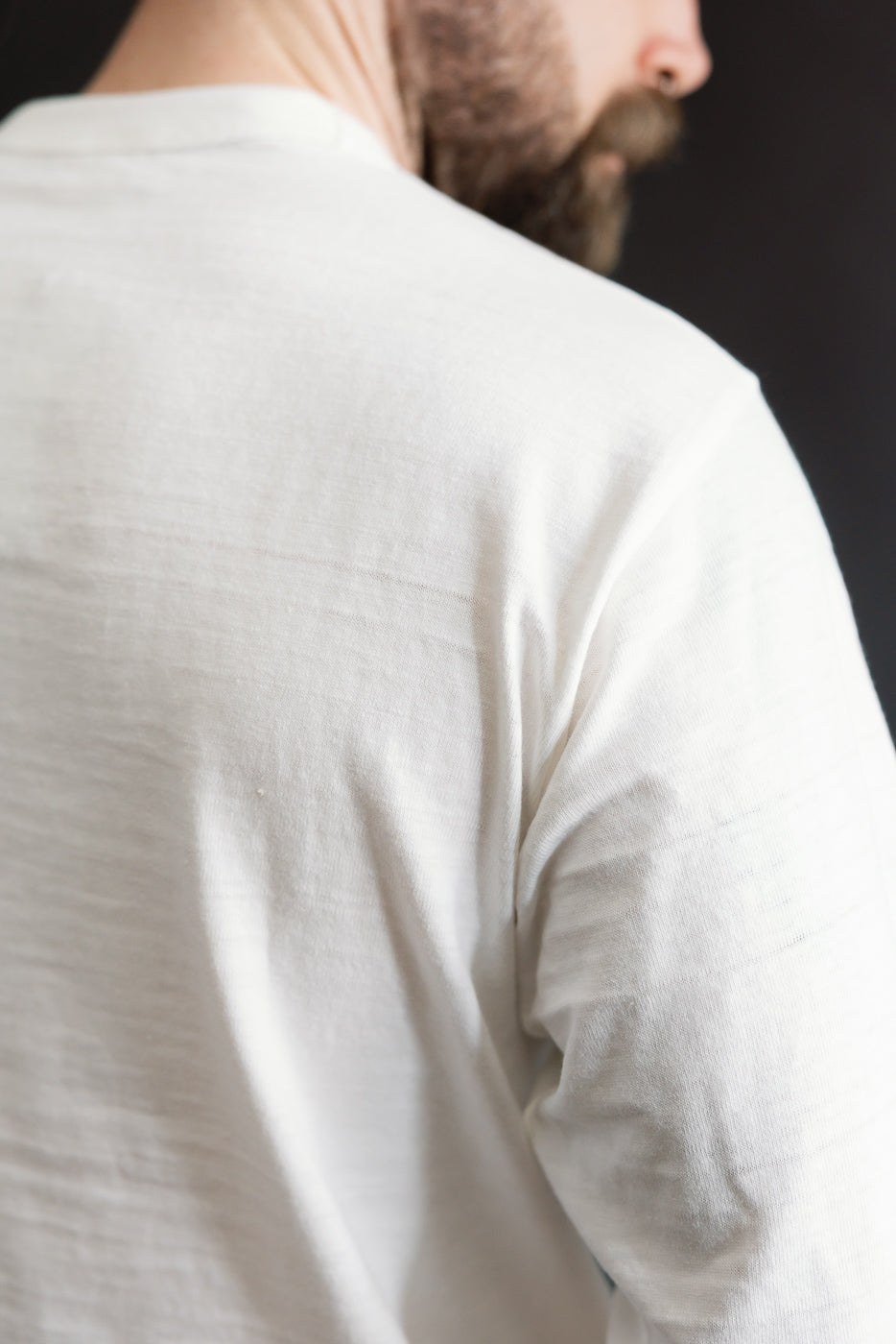 Close-up of back shoulder detail, Warehouse & Co. slubby off-white long sleeve T-shirt, worn by male model 5'9