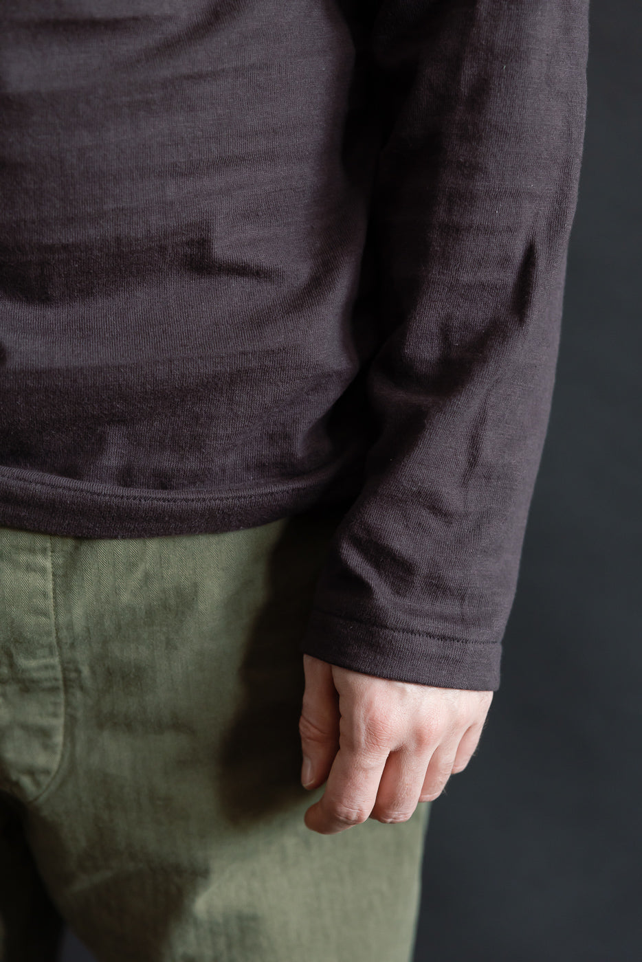 Close-up of front hem and sleeve of Warehouse & Co. slubby cotton long sleeve T-shirt on male model, 5'9