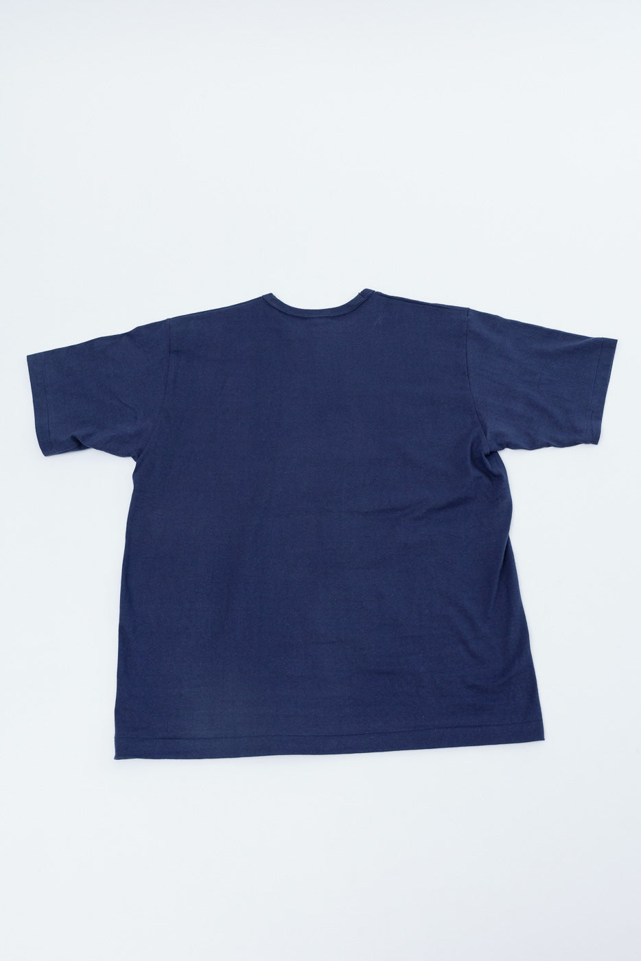 Flat lay of the back of a navy blue short-sleeve t-shirt.