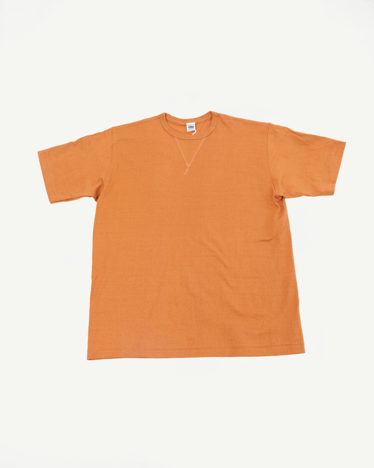 Front view flat lay of an orange short-sleeve t-shirt with a crew neck and visible neck tag.