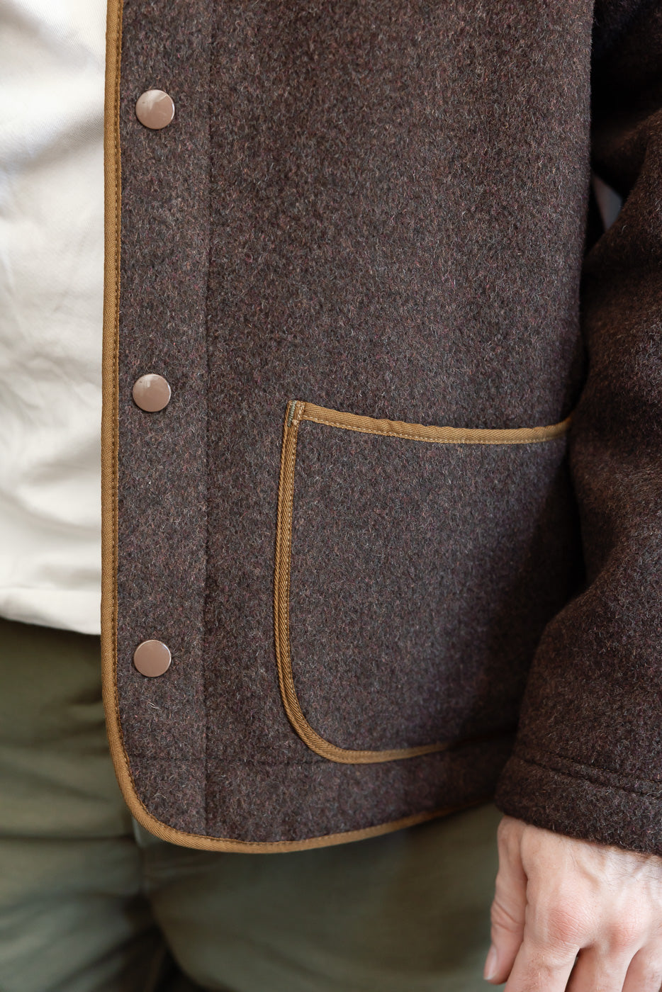 Close-up of the front left of a brown tweed blazer on a male model, 5'9