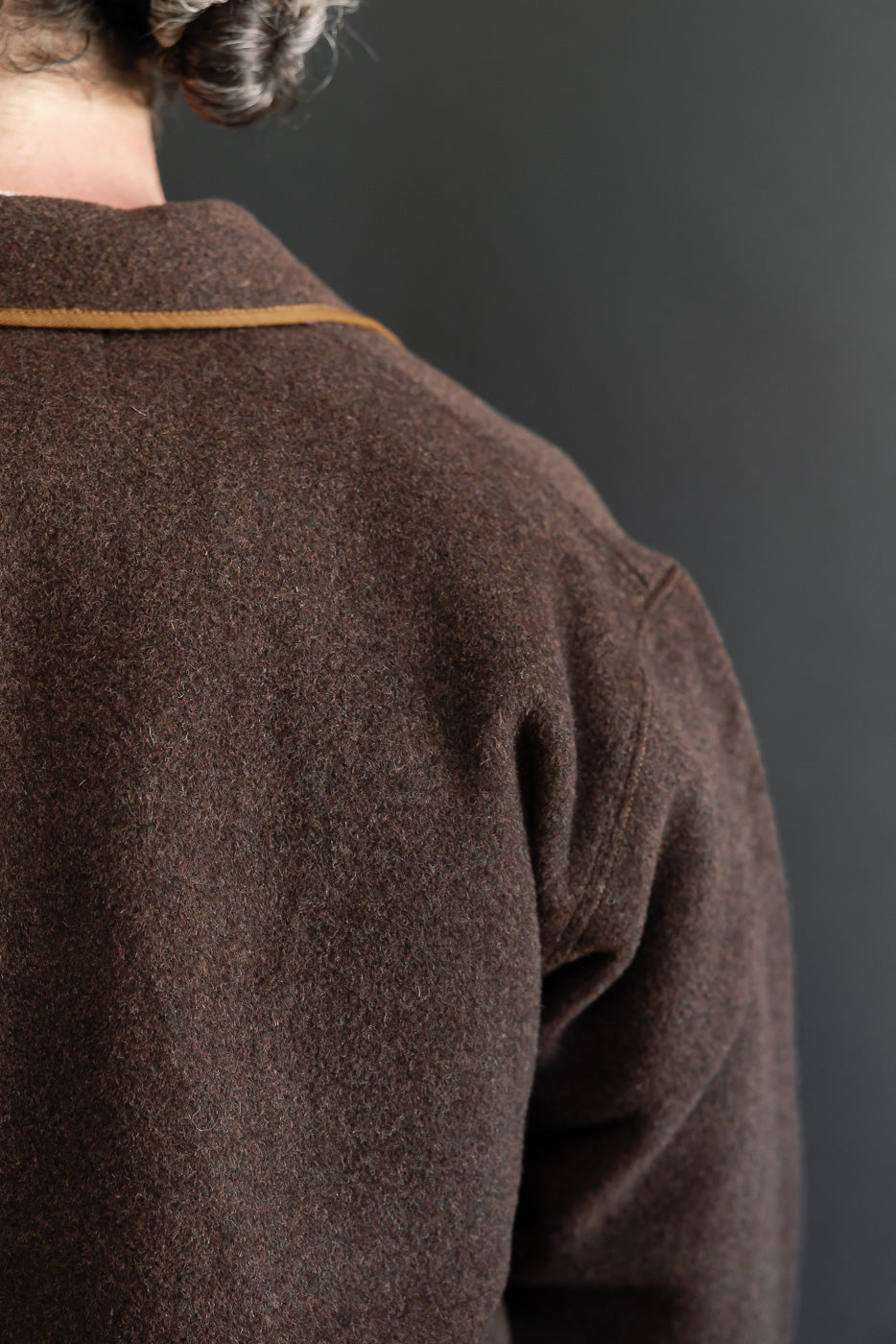 Close-up back view of a brown wool jacket on a male model, 5'9