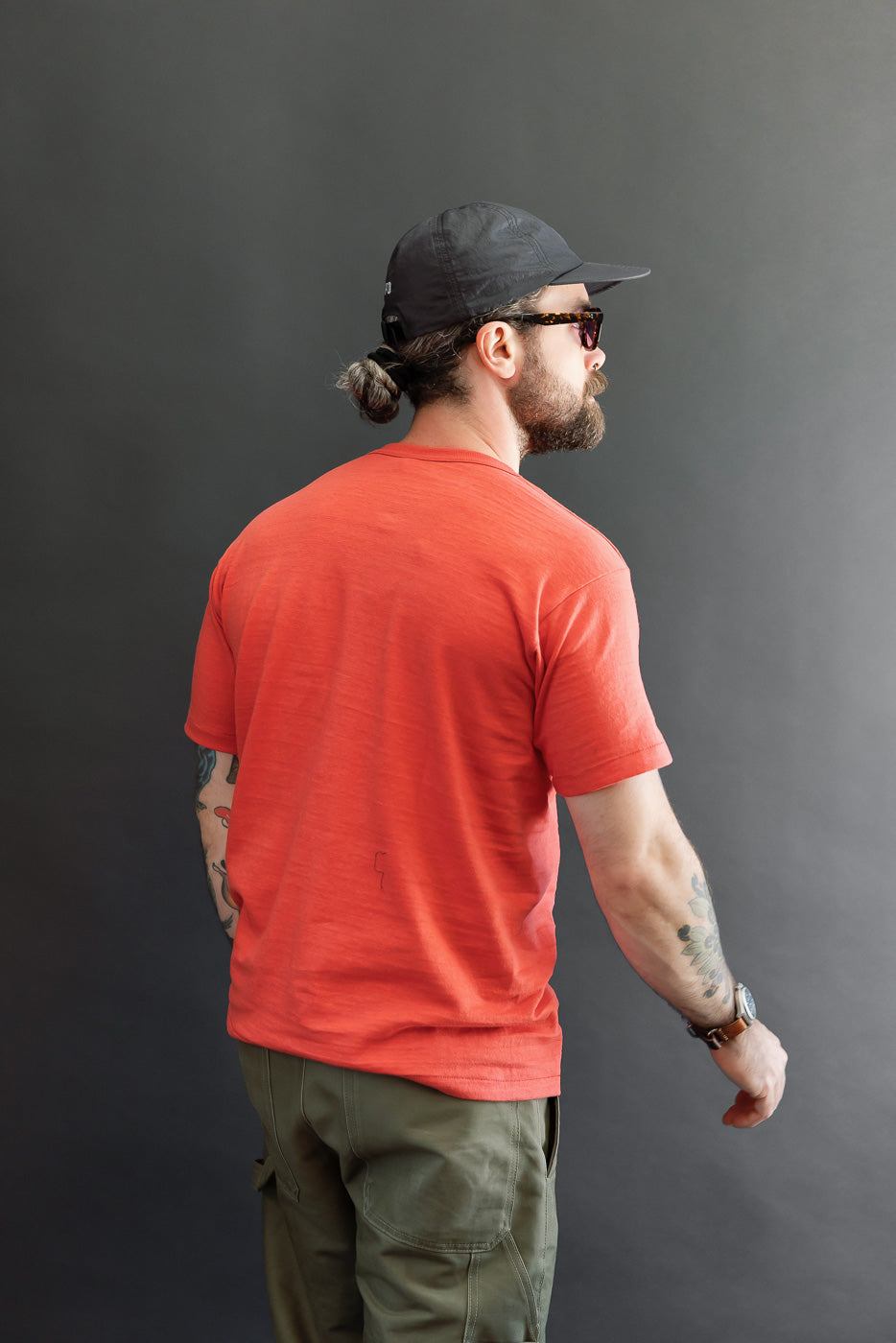Back view of a red t-shirt on a male model, 5'9
