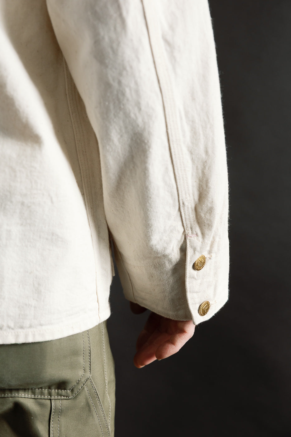 Close-up of sleeve cuff and buttons on ecru painter's jacket, male model 5'9