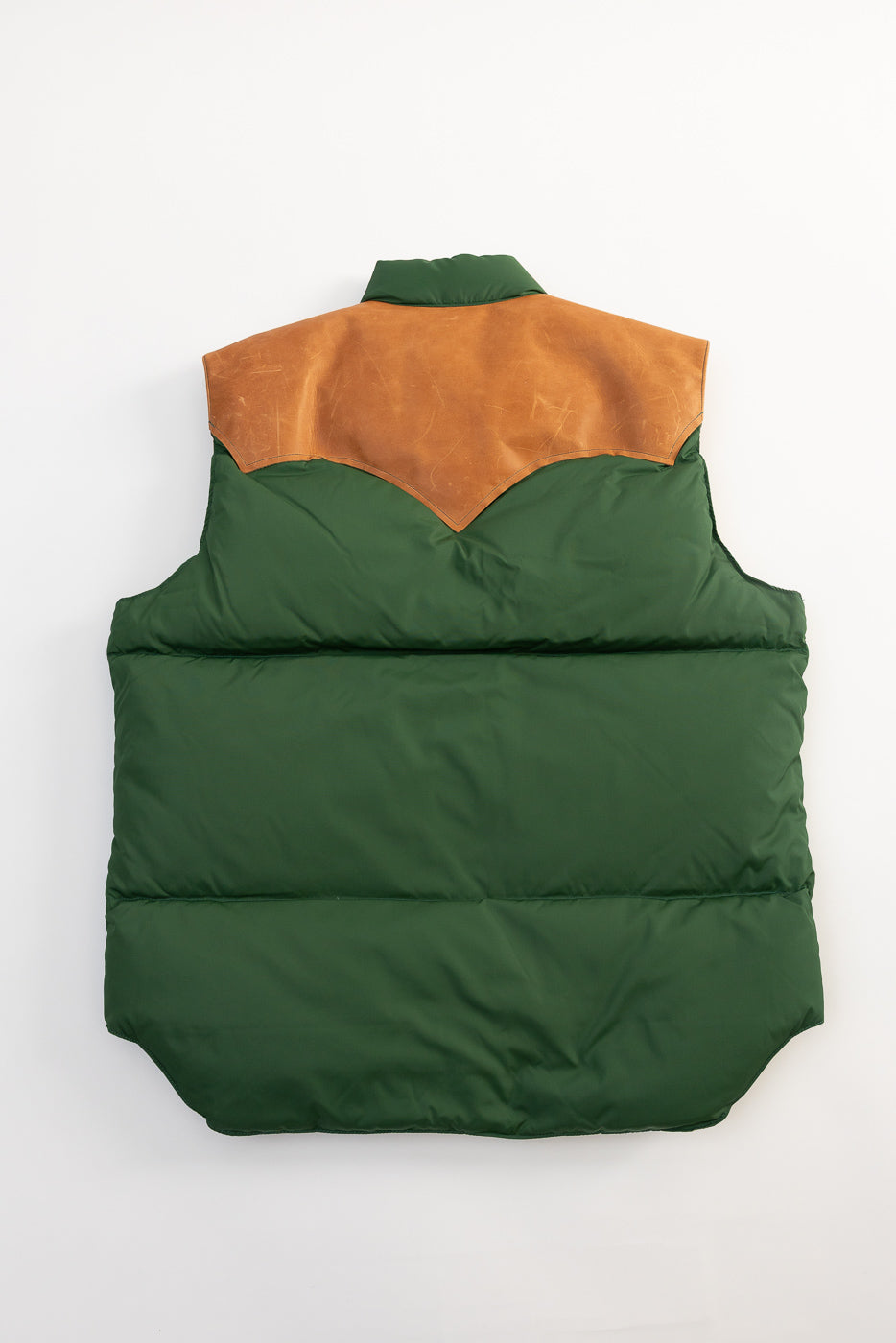 Flat lay, back view of bottle green nylon down vest with tan leather yoke, Dant apparel