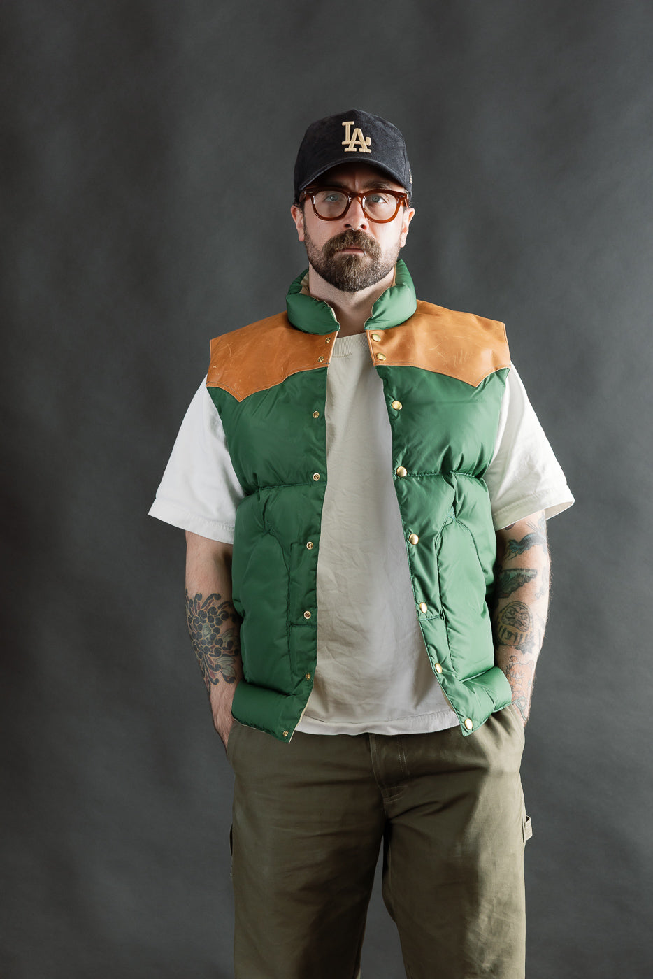 Front view of bottle green nylon down vest with tan yoke on male model, 5'9