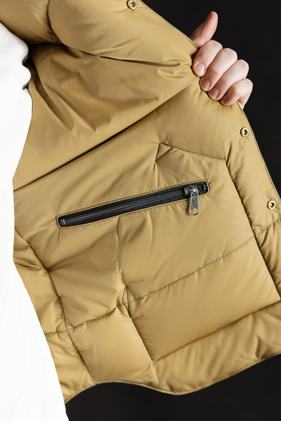 Close-up of inner left side of OD green HBT down vest, showing zip pocket and fabric detail