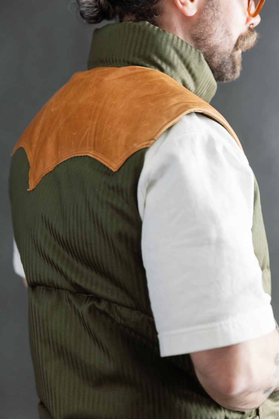 Close-up of OD green Rocky Mountain HBT down vest, back shoulder detail, on male model 5'9