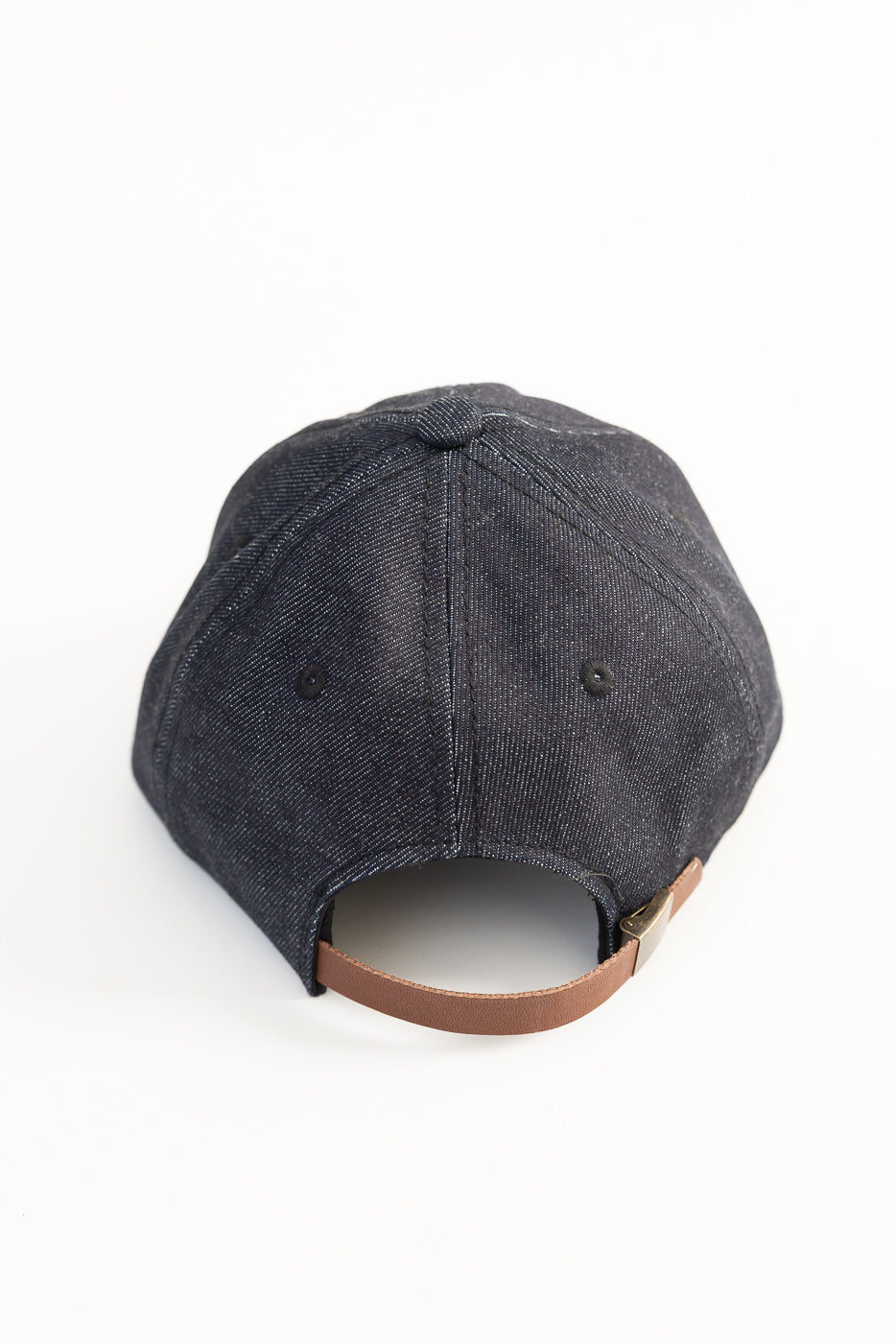 Close-up rear view of Warehouse Lot 303 Strong denim baseball cap in dark indigo, showing brown leather adjustable strap and metal clasp detail.