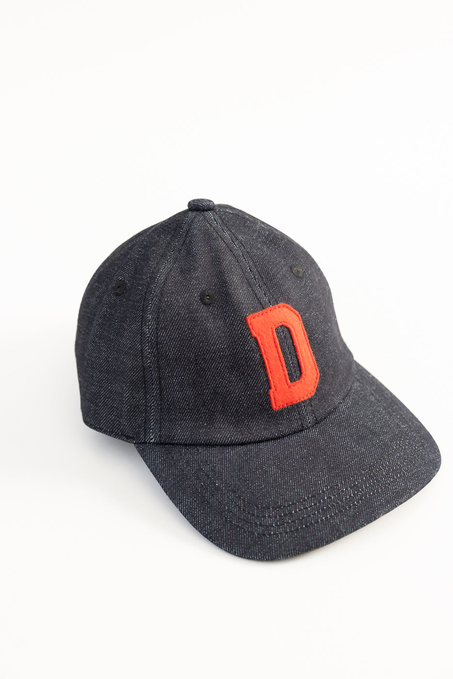 Angled close-up of Warehouse Lot 303 Strong Denime indigo baseball cap with red D patch, front view.