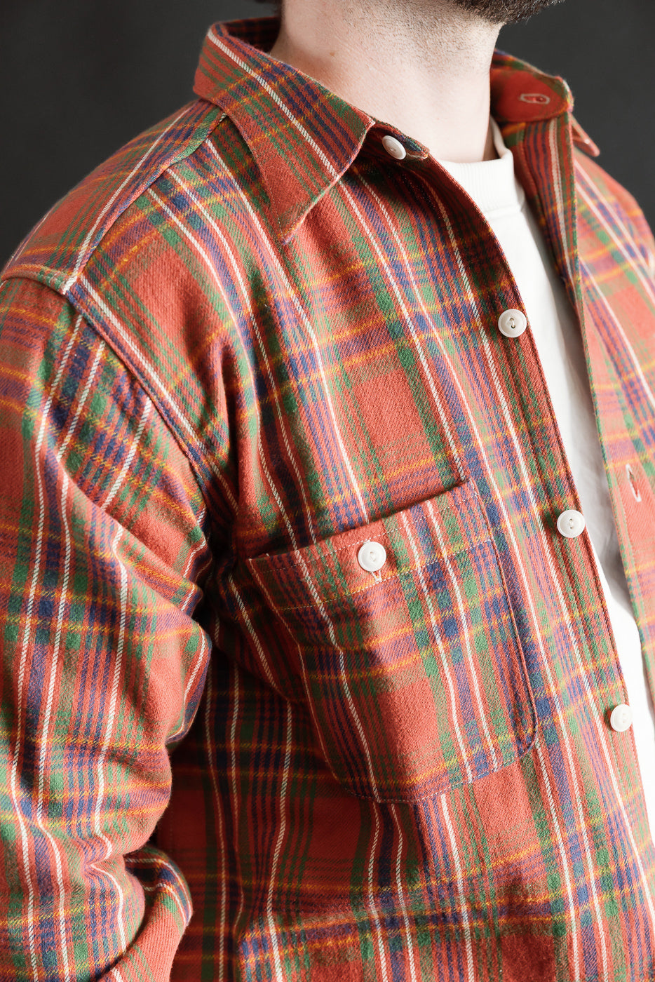 Close-up front view of 1940s-inspired red plaid storm shirt on male model, 5'9