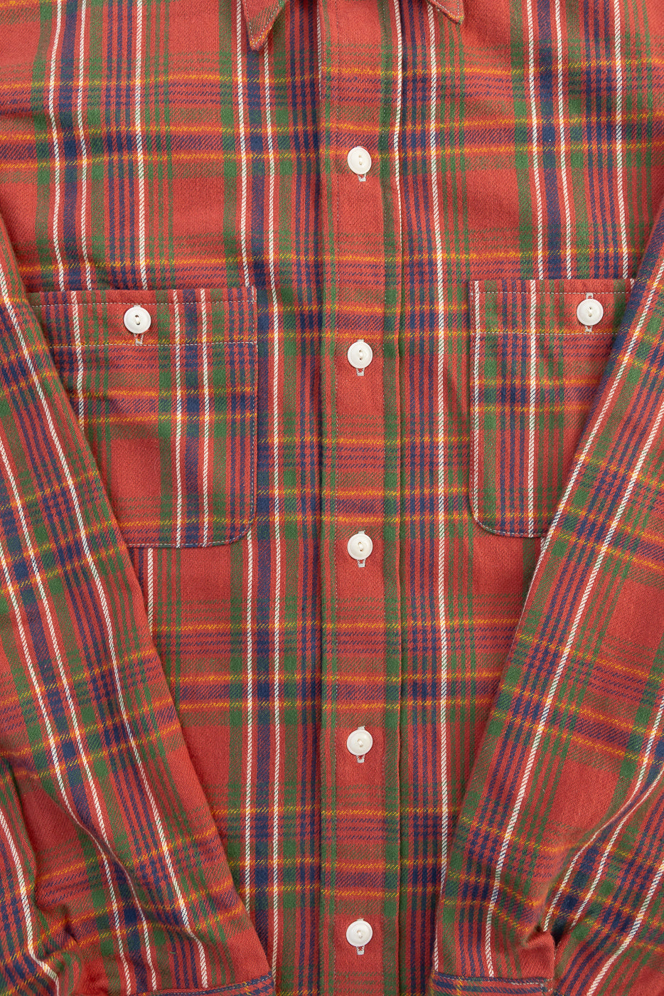 Close-up front view of red plaid storm shirt showing buttons, fabric texture, and chest pockets.
