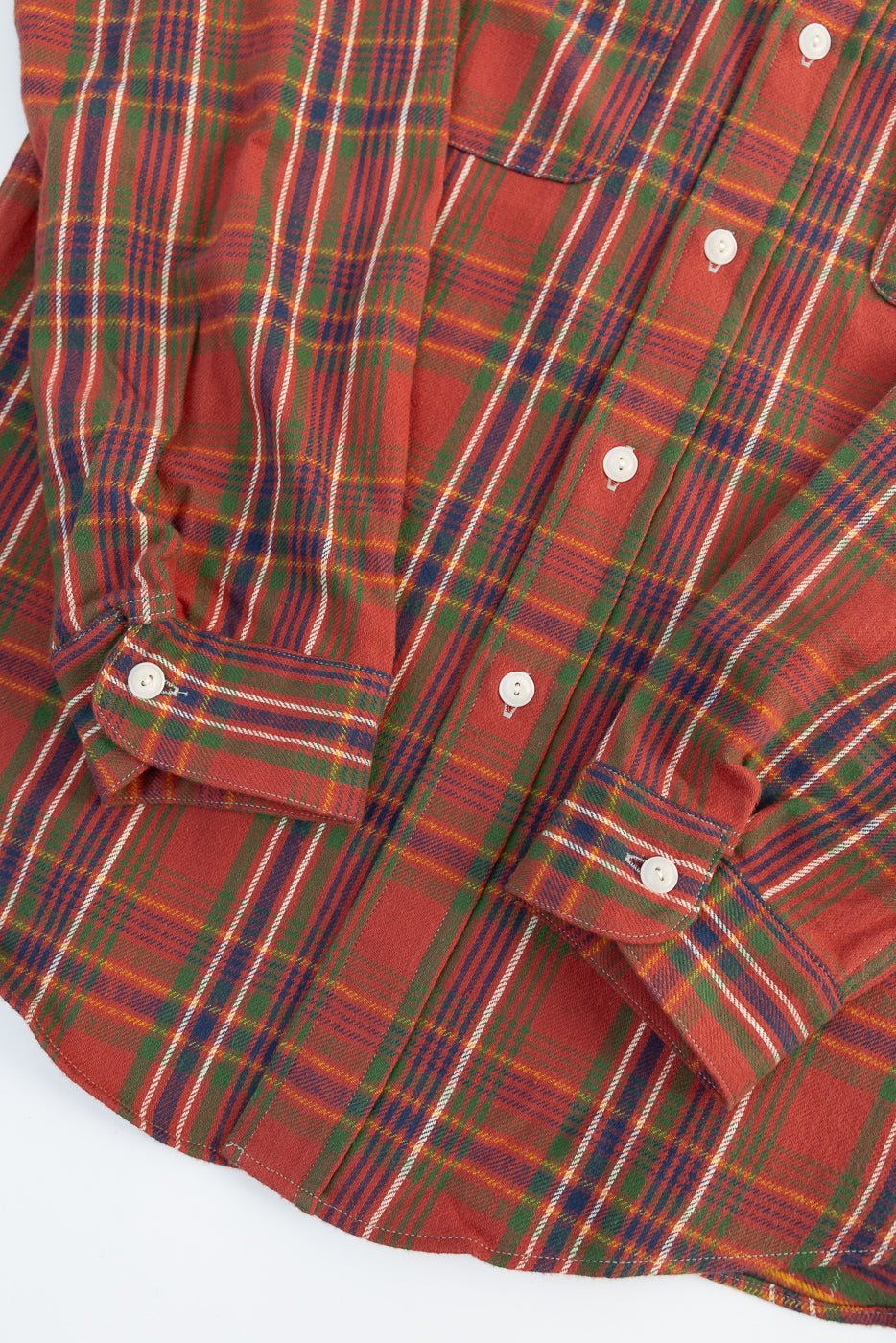 Close-up front view of red plaid selvedge shirt showing sleeve cuffs, buttons, and fabric texture