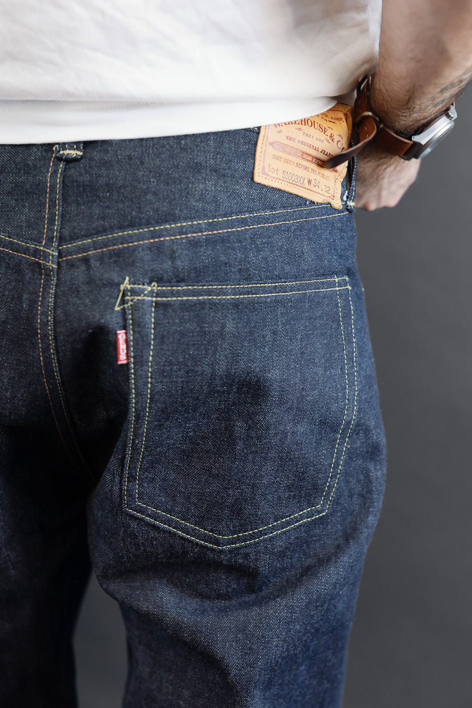 Close-up back view of raw denim jeans on a male model (5'9