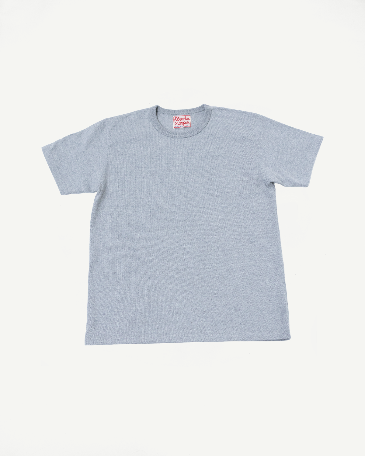 Flat lay of the front of a light blue t-shirt showing the crew neck and brand tag.