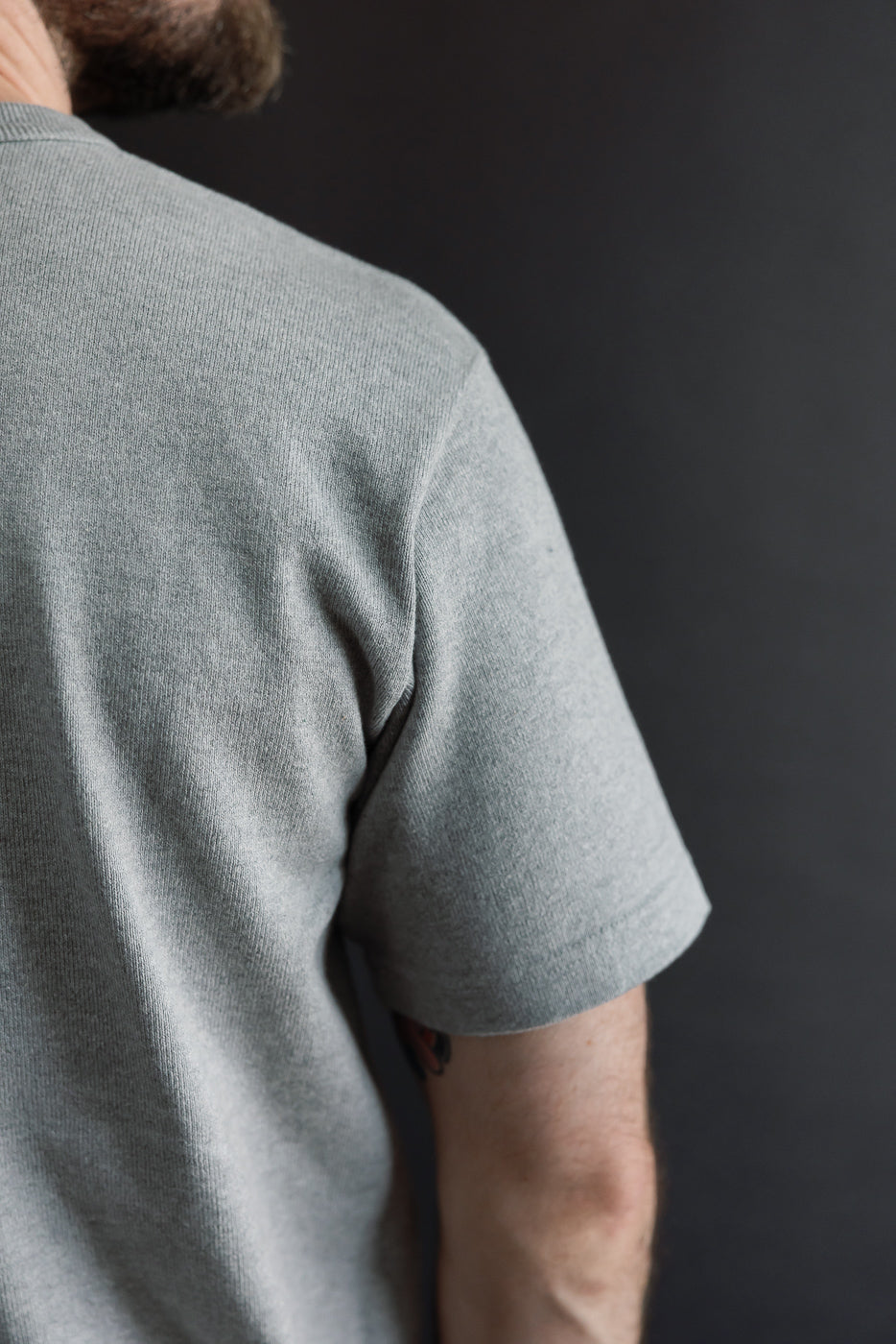 Close-up back view of a grey t-shirt on a male model, 5'9