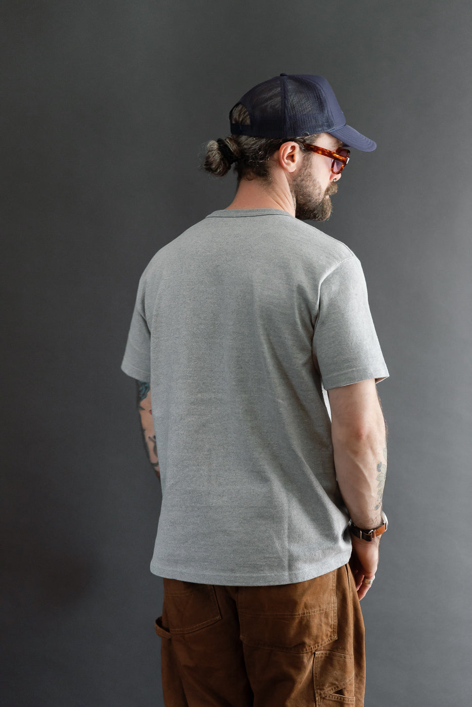 Back view of a grey t-shirt on a male model, 5'9