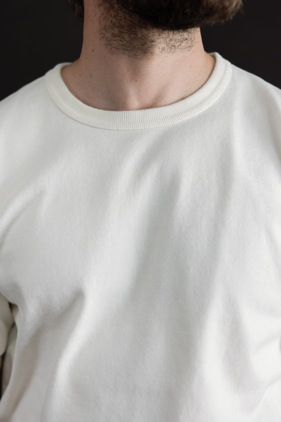 Close-up front view of a white crewneck sweatshirt on a 5'9