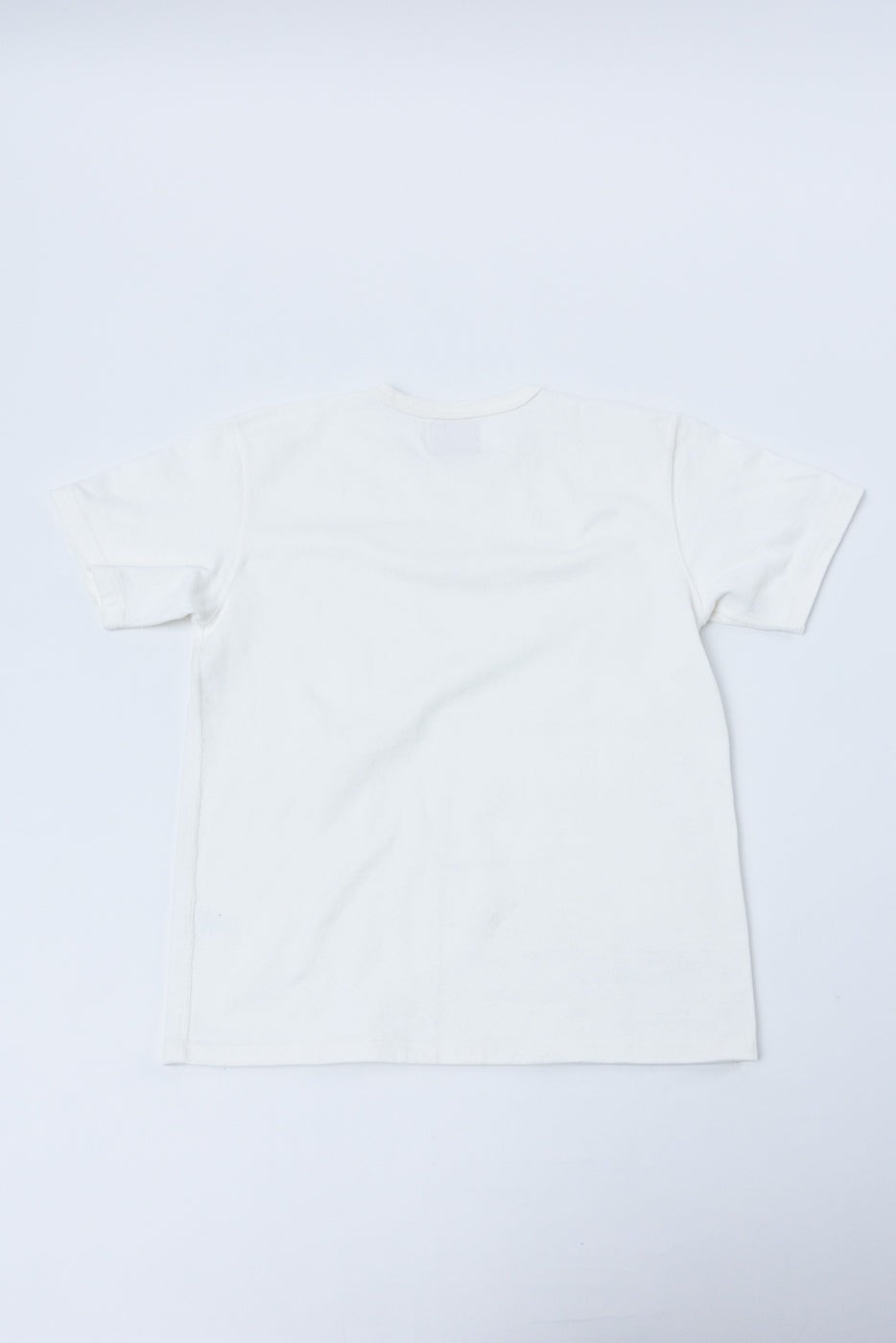 Flat lay showing the back of a plain white short-sleeve t-shirt.