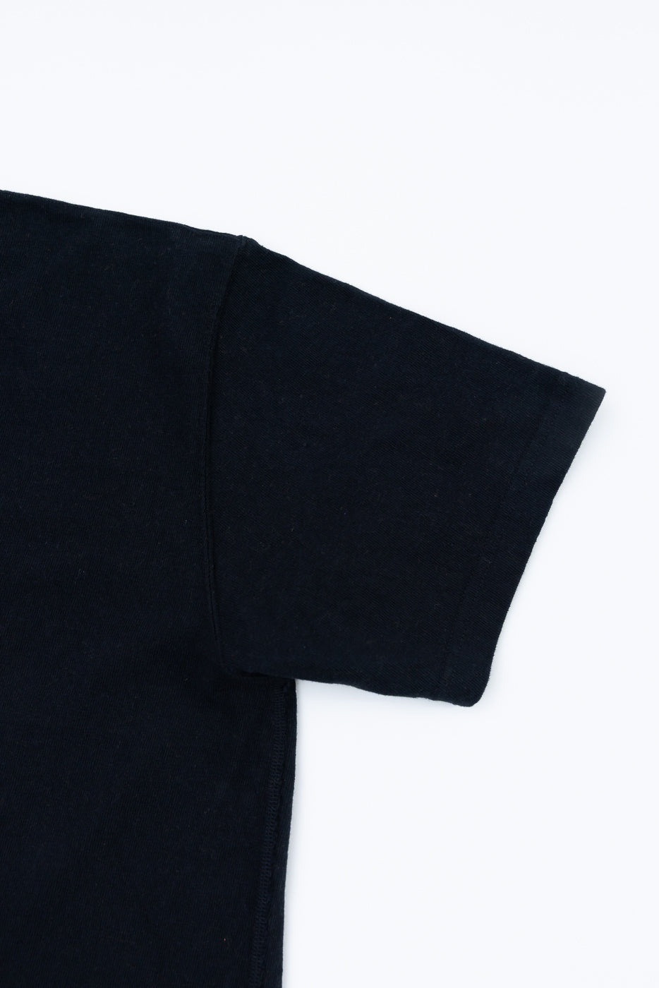 Close-up of the ELS Recycled Cotton Slub Crewneck T-Shirt - Black, showcasing the detailed sleeve and flat side seam construction, reflecting its premium Japanese craftsmanship and unique textured fabric.