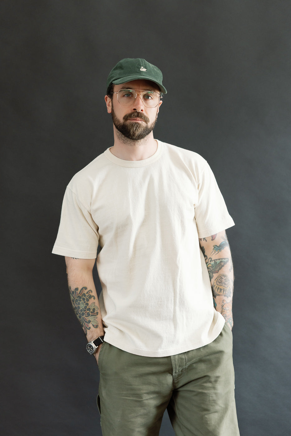 Model wearing the ELS Recycled Cotton Slub Crewneck T-Shirt - Ecru, paired with olive-green pants, showcasing its modern athletic fit and textured fabric, embodying Dant's premium menswear style.