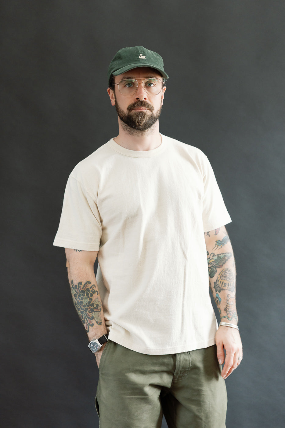 Man wearing the ELS Recycled Cotton Slub Crewneck T-Shirt - Ecru, showcasing its athletic fit and textured fabric. He stands with relaxed arms against a neutral backdrop, highlighting the shirt's premium craftsmanship.