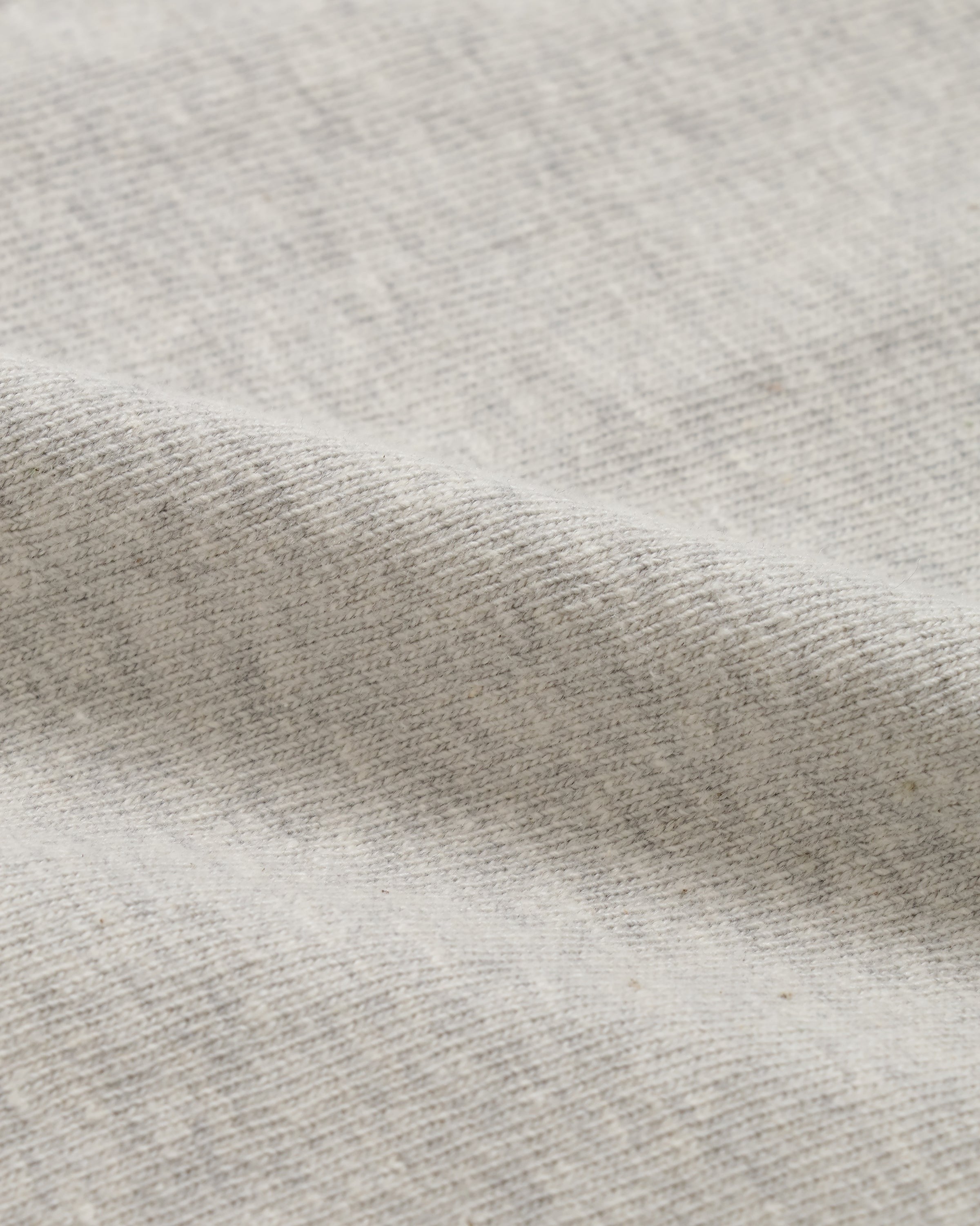 Close-up of recycled cotton slub crewneck t-shirt fabric, heather grey texture detail.