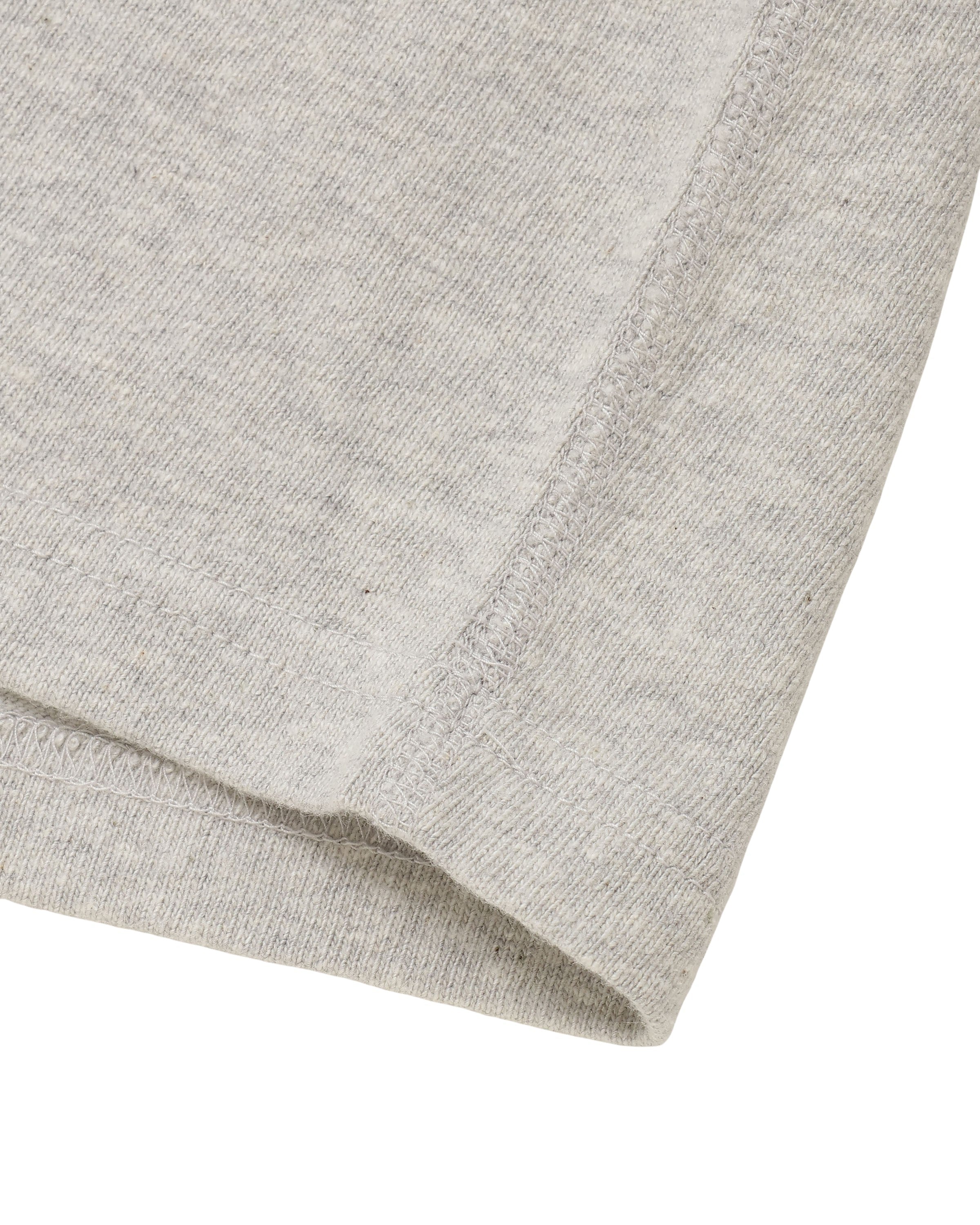 Close-up of recycled cotton slub crewneck T-shirt, heather grey, showing hem stitching detail.