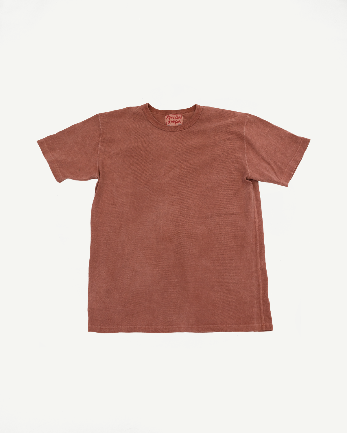 Flat lay front view of rust-colored short sleeve tee with ribbed crew neck and visible brand tag
