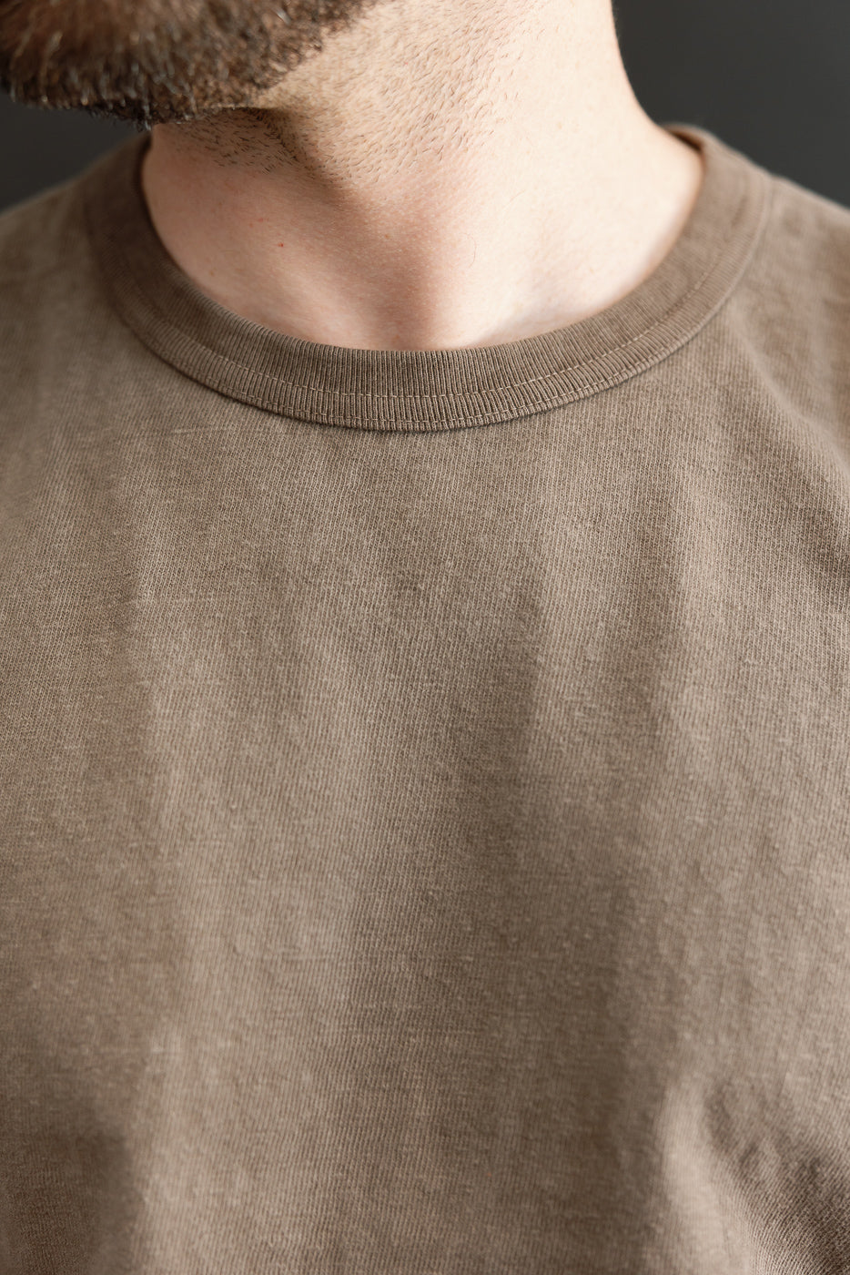 Close-up front view of olive crew neck tee on male model, 5'9