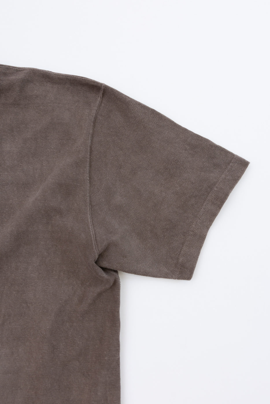 Close-up of brown t-shirt sleeve, showing fabric texture and hem detail