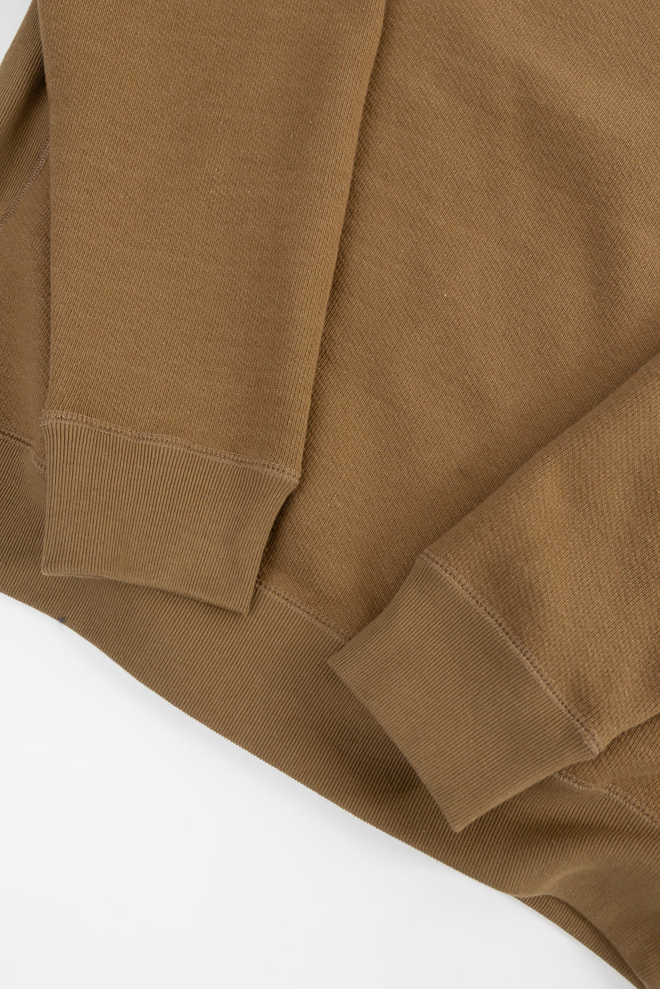 Close-up of Dant Wonder Looper pullover crewneck cuff, hem, and sleeve texture in dune brown, flat lay front view.