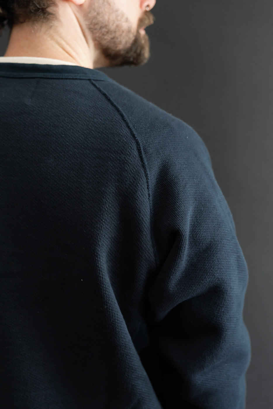 Close-up back view of navy textured sweater on a 5'9