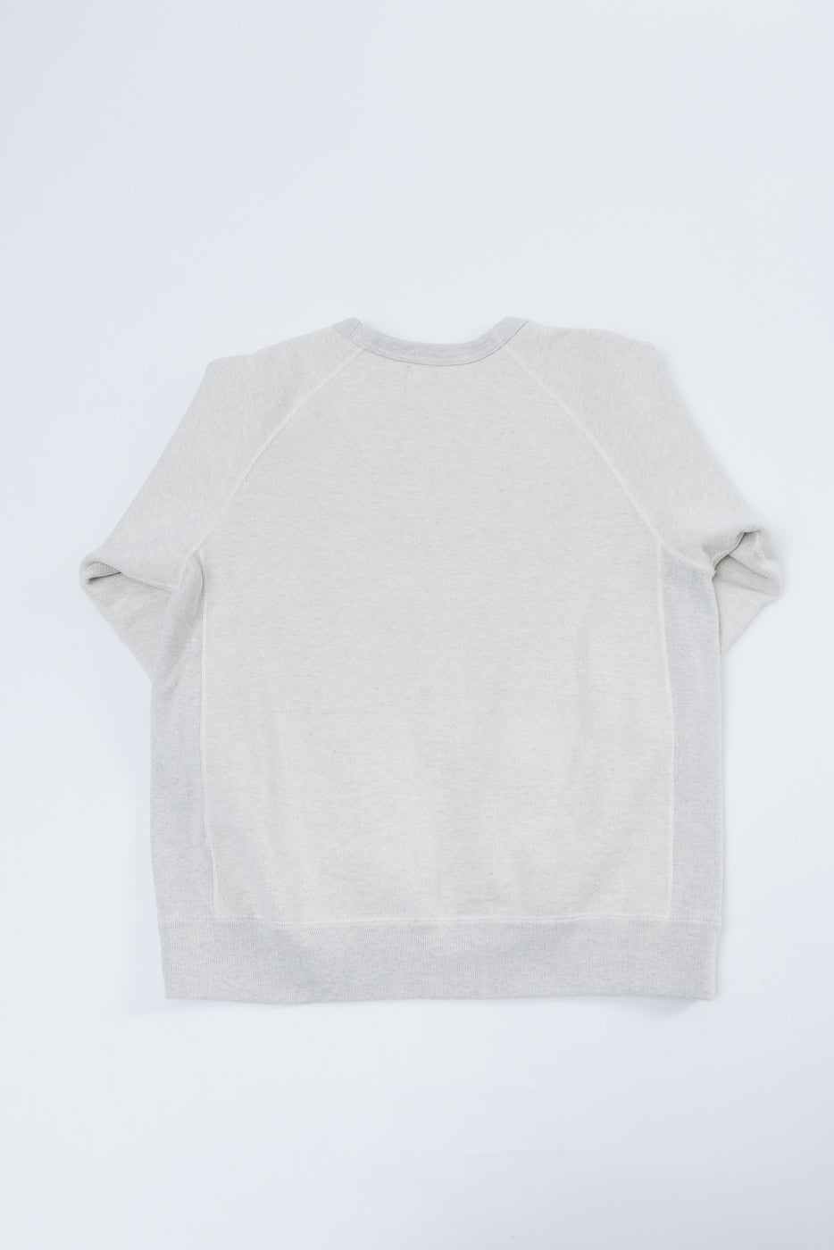 Flat lay back view of a light grey crewneck sweatshirt with raglan sleeves.